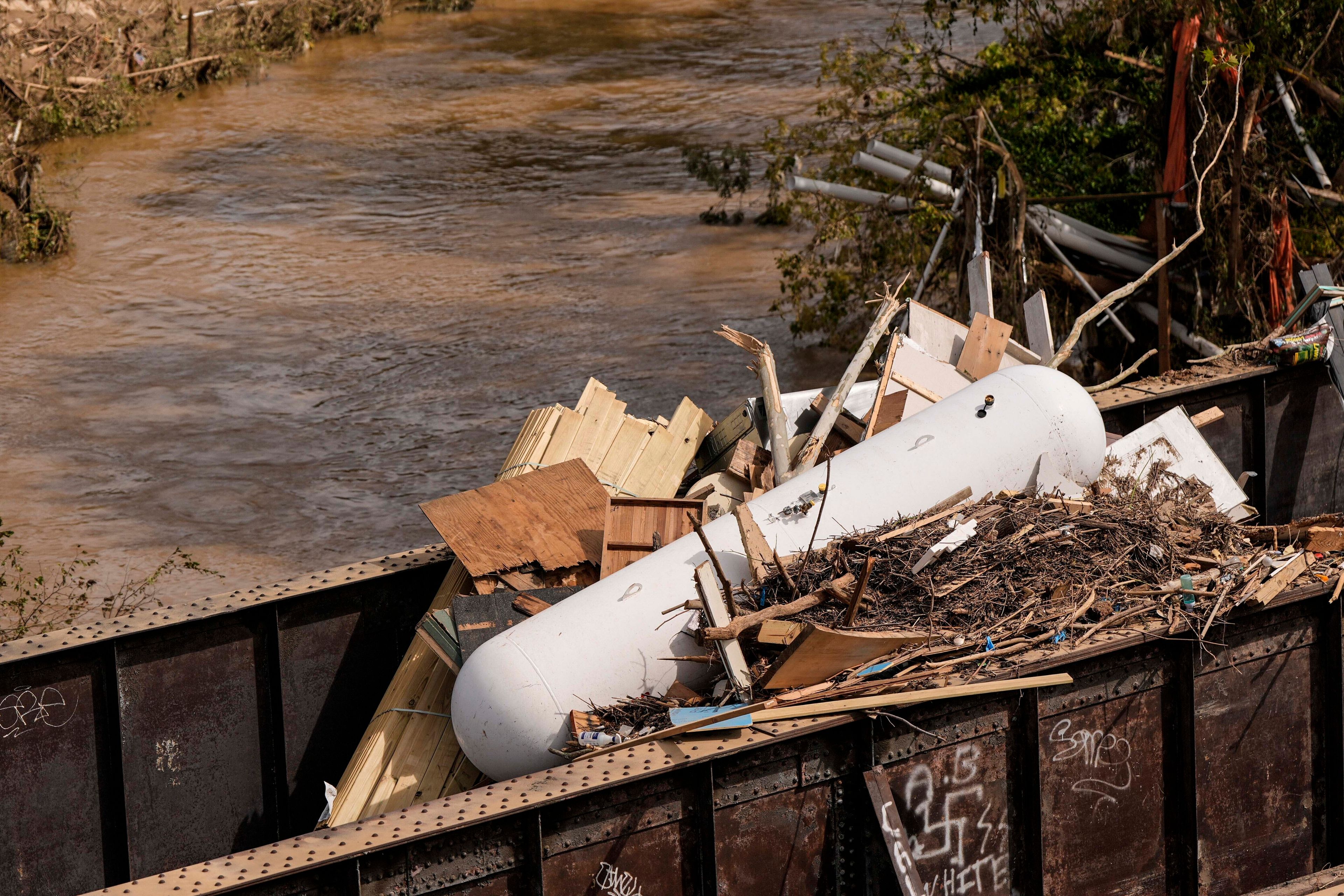 A gas natural gas tank lies with other debris on a train bridge in the aftermath of Hurricane Helene, Monday, Sept. 30, 2024, in Asheville, N.C. (AP Photo/Mike Stewart)