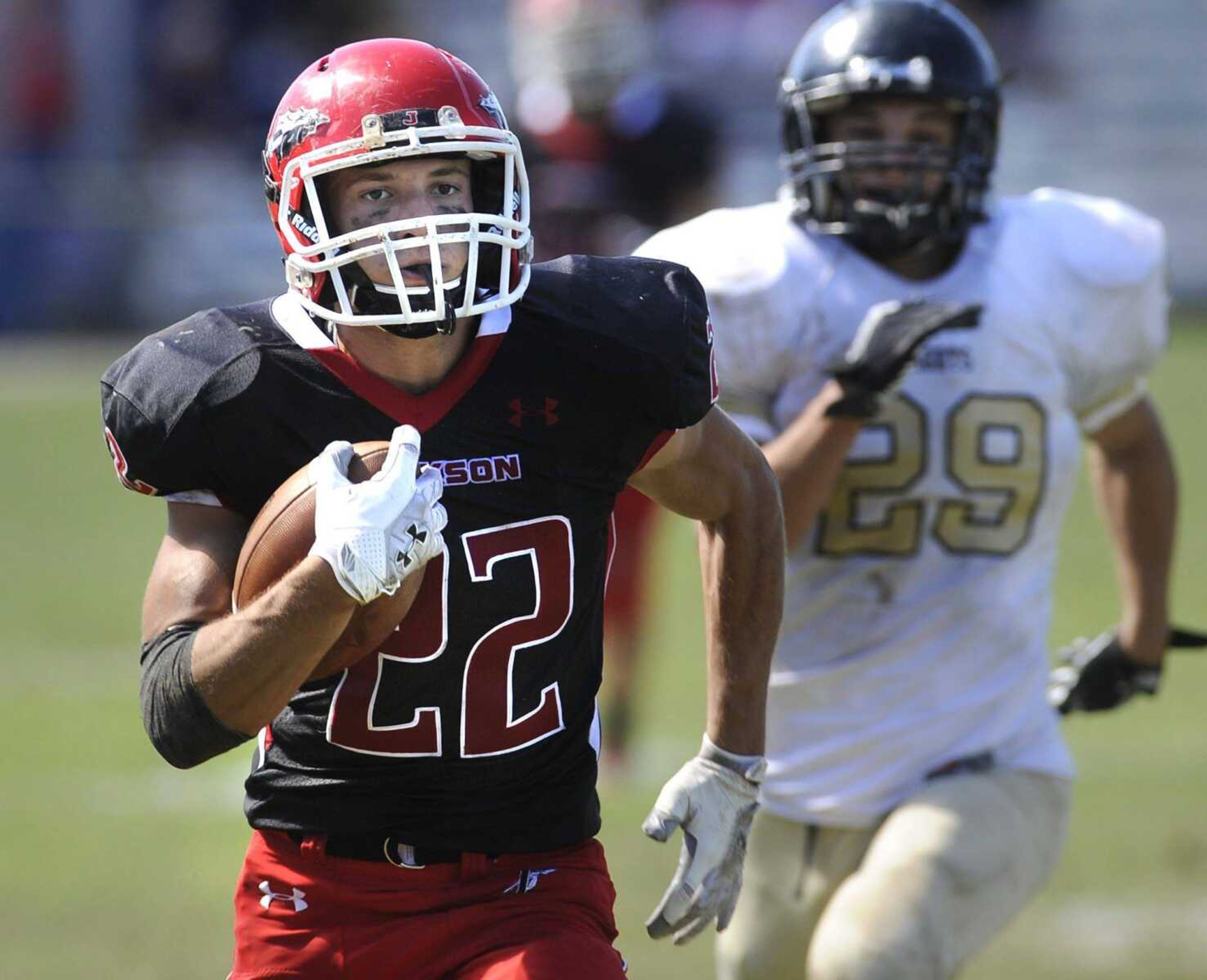 Jackson&#8217;s Brannon Wright runs away from Farmington&#8217;s Anthony Greco to score a touchdown during the second quarter Saturday at Jackson High School. (Fred Lynch)