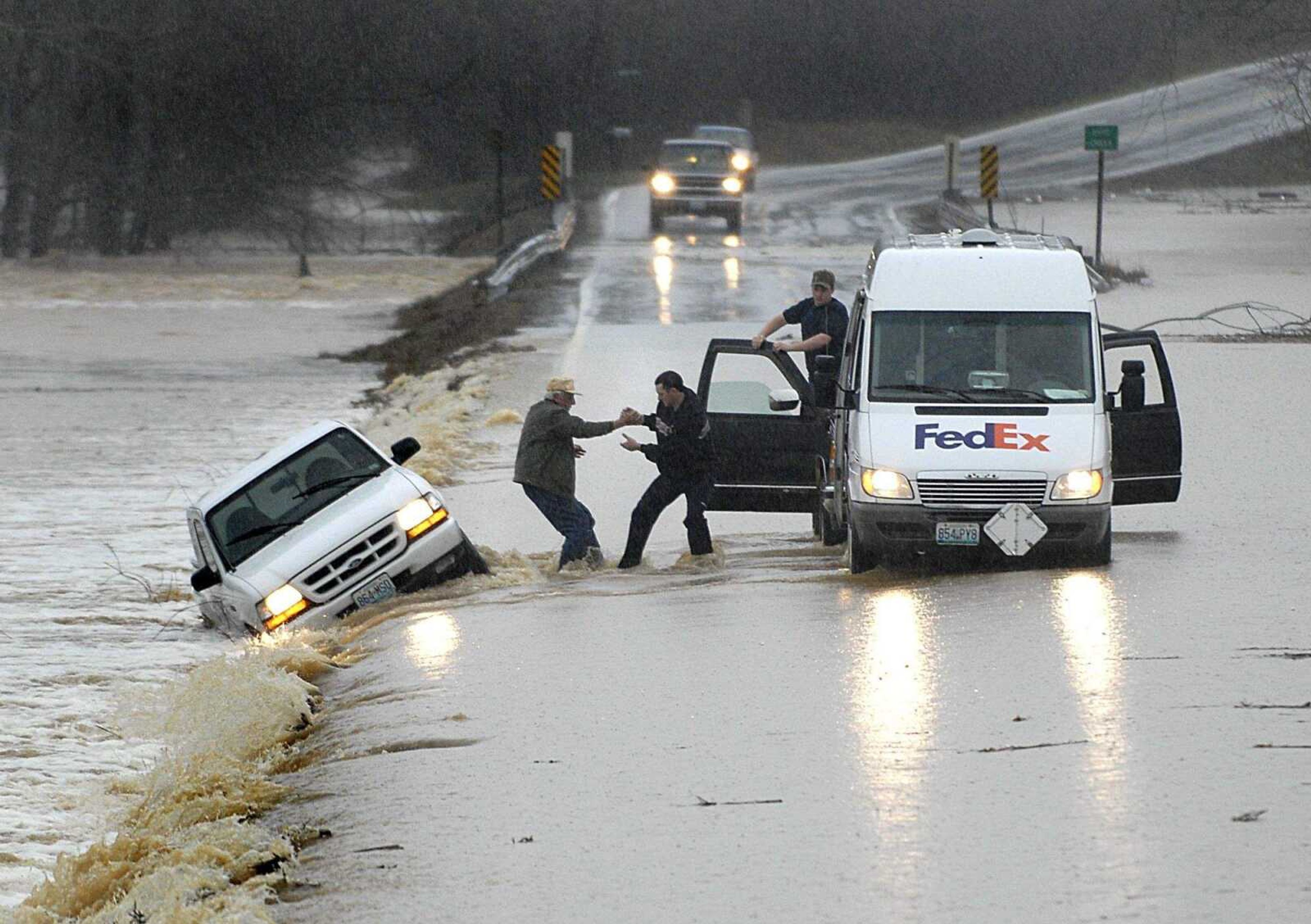 AARON EISENHAUER ~ aeisenhauer@semissourian.com
Fedex driver Jay McMullin helps 78-year-old Odell Bunch into the delivery truck after Bunch's Ford Ranger was swept off of Hwy 34 by flood waters on Tuesday, March 18, 2008 west of Jackson.