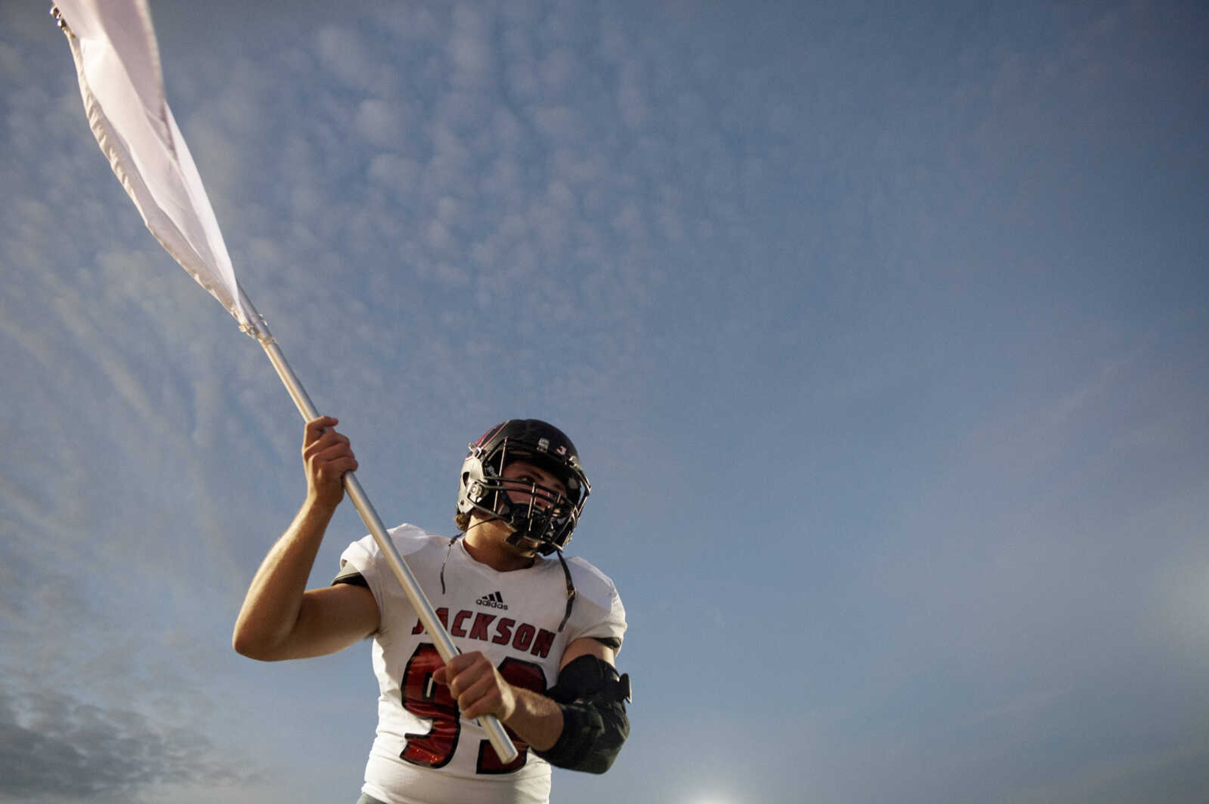 Jackson's Cole Amelunke (99) waves a flag as the team prepares to the take the field before the start of the Jackson Indians' 35-14 victory over Farmington on Friday, Oct. 4, 2019, in Farmington, Missouri.