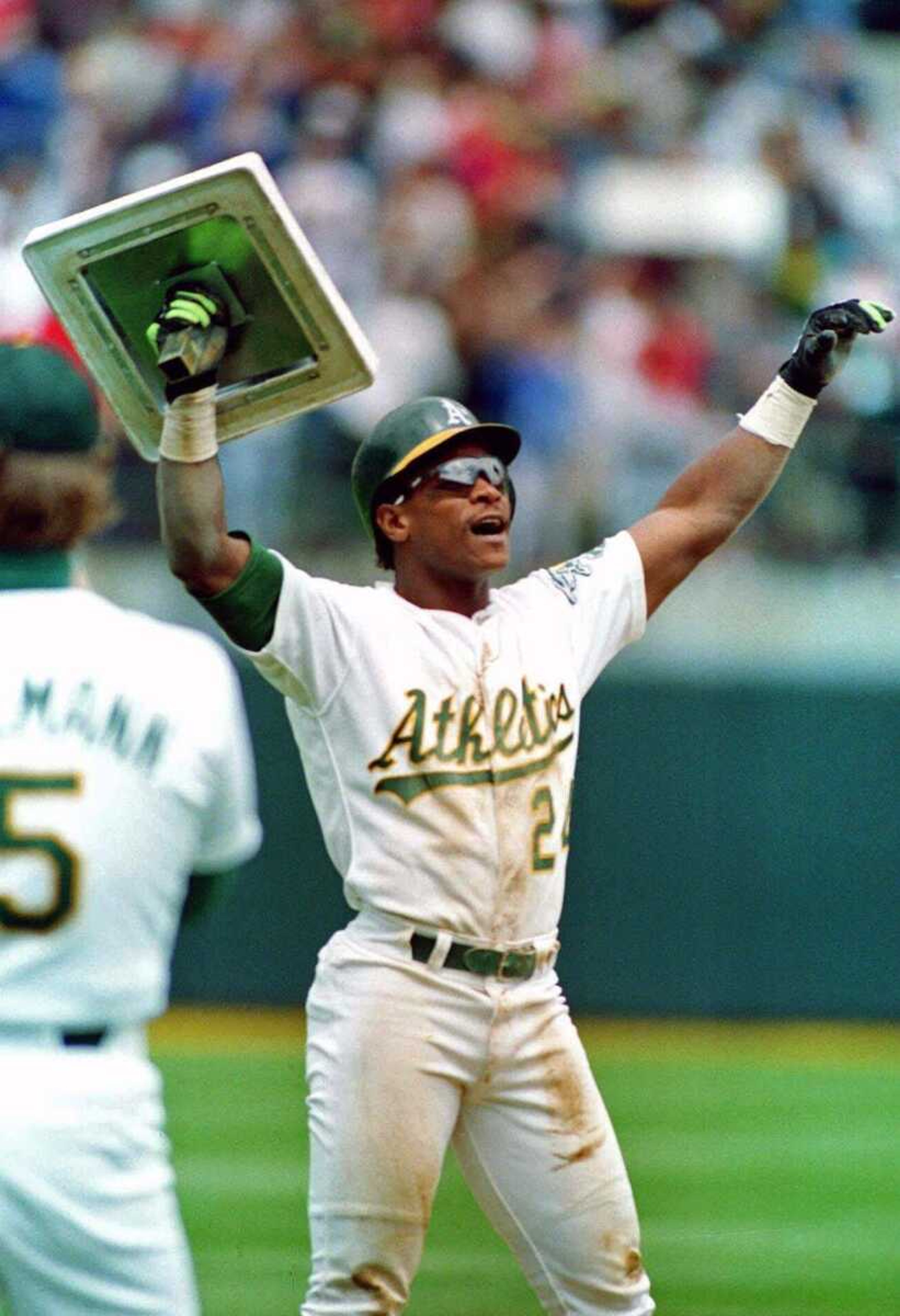 Associated Press file<br>Rickey Henderson holds up third base after breaking Lou Brock's all-time career record for stolen bases while playing for the Oakland Athletics in 1991.