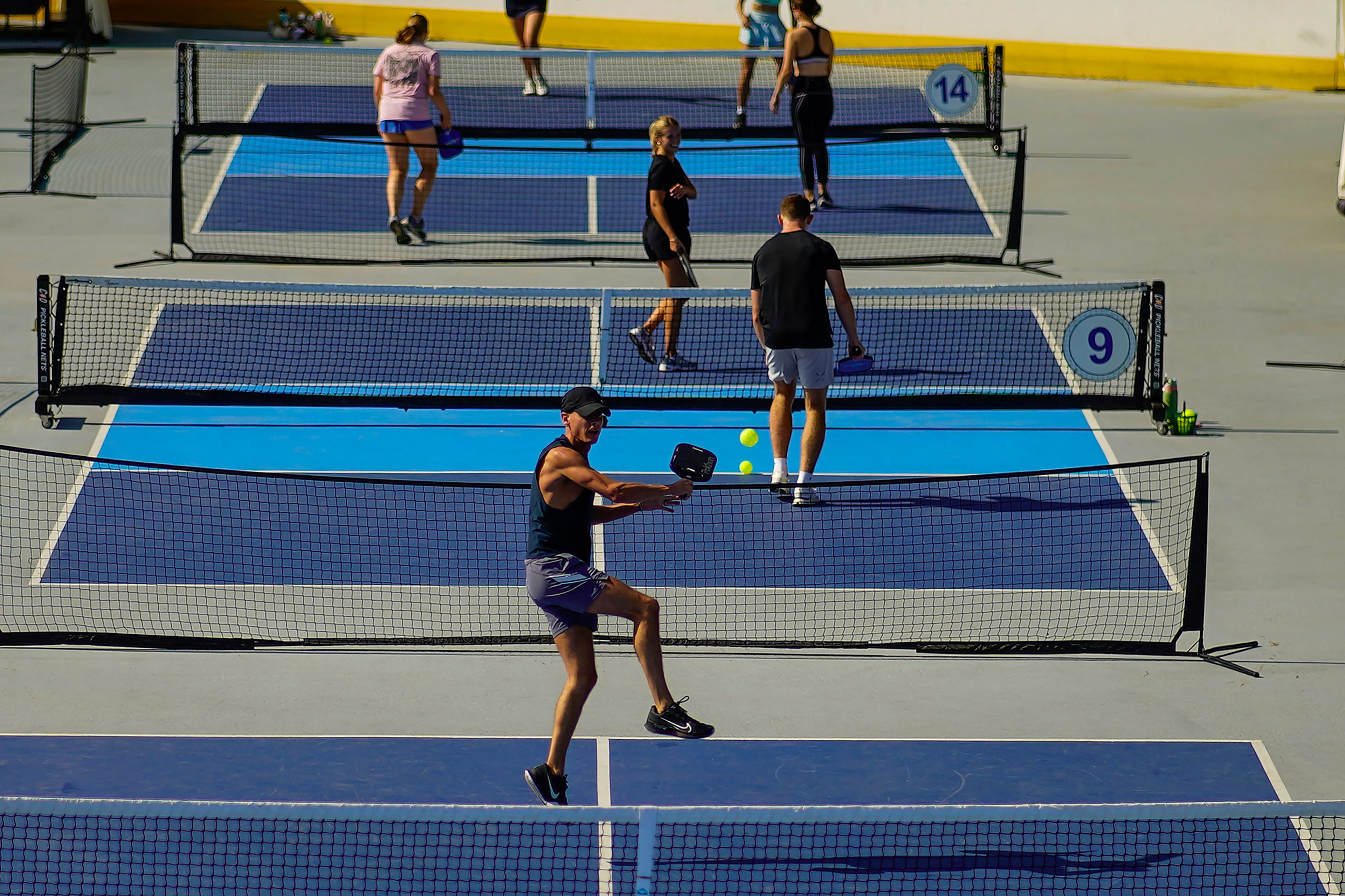 A man jumps to return the ball as people practice pickleball on the courts of CityPickle at Central Park's Wollman Rink, Saturday, Aug. 24, 2024, in New York. (AP Photo/Eduardo Munoz Alvarez)