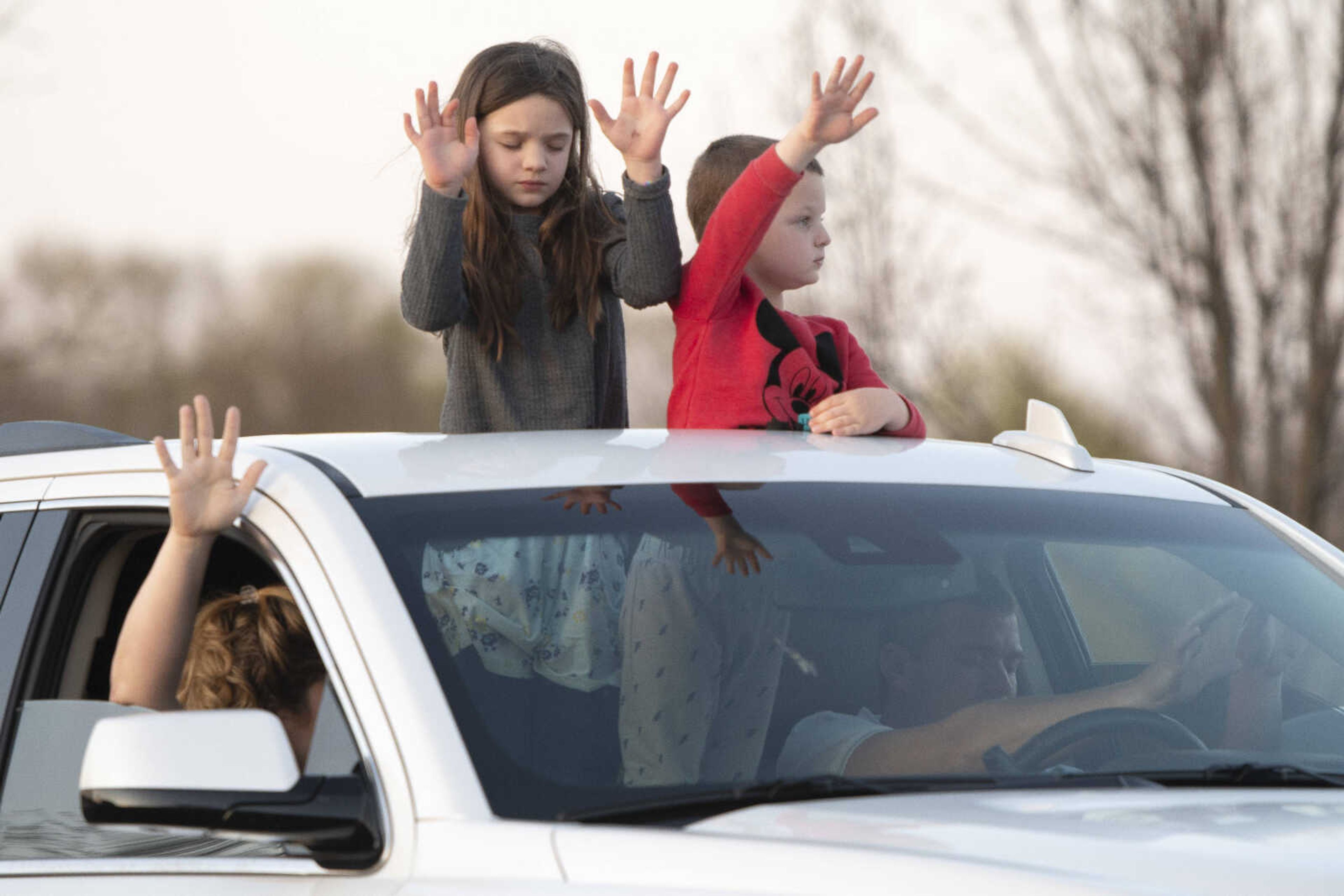 Statler siblings Bella, 7, and Carter, 4, of Oak Ridge, take part in a "park and pray" event with their parents Paige and Rusty Statler, in passenger and driver seats respectively, on Tuesday, March 31, 2020, outside Southeast Hospital in Cape Girardeau. Christy Brey of Jackson, who organized the event, said people also gathered Monday at Saint Francis Medical Center. "Obviously there's a lot going on with the scares and the panic of COVID and just the fears of people," Brey said. She said she had the idea after seeing a post about a similar event on social media. "It's just to kind of rally the community," she said. Brey said people at the event were supposed to stay in their vehicles and "stay within the guidelines of safety."