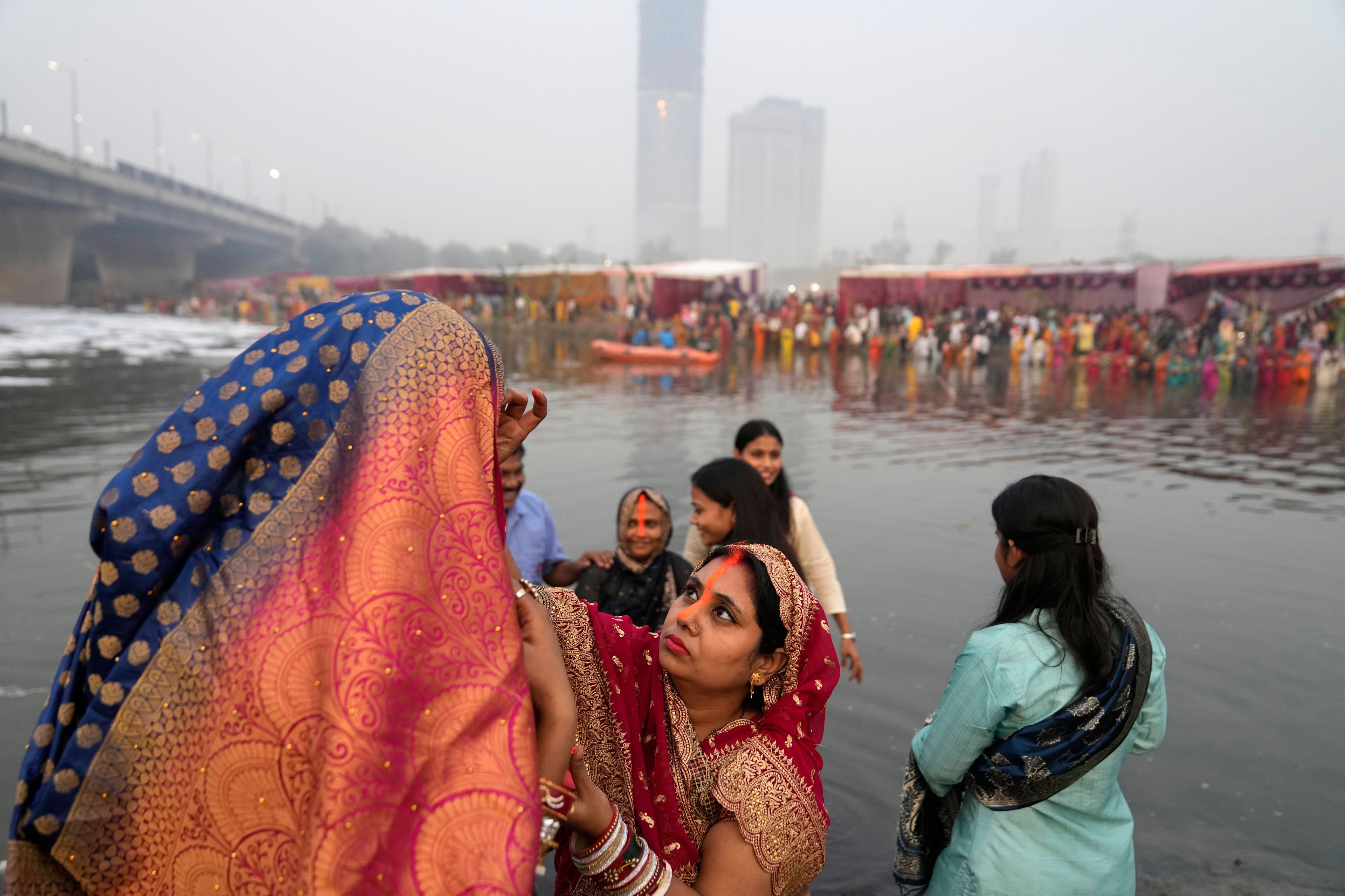 Women devotees get ready on the banks of the river Yamuna to offer prayers to the sun god during Chhath festival in Noida, near New Delhi, India, Thursday, Nov. 7, 2024. (AP Photo/Manish Swarup)