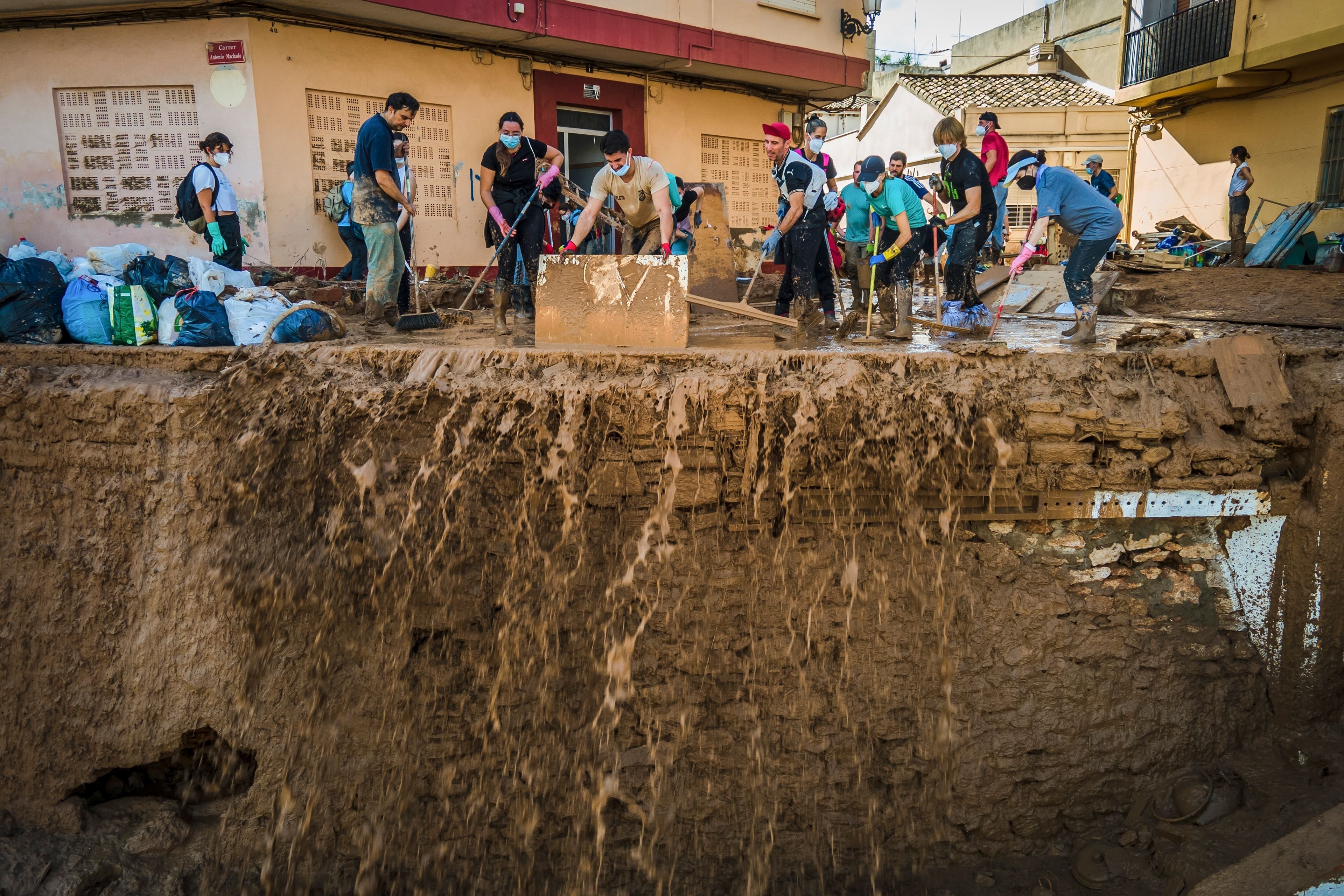 Volunteers and residents cleanup the mud four days after flash floods swept away everything in their path in Paiporta, outskirts of Valencia, Spain, Saturday, Nov. 2, 2024.(AP Photo/Angel Garcia)