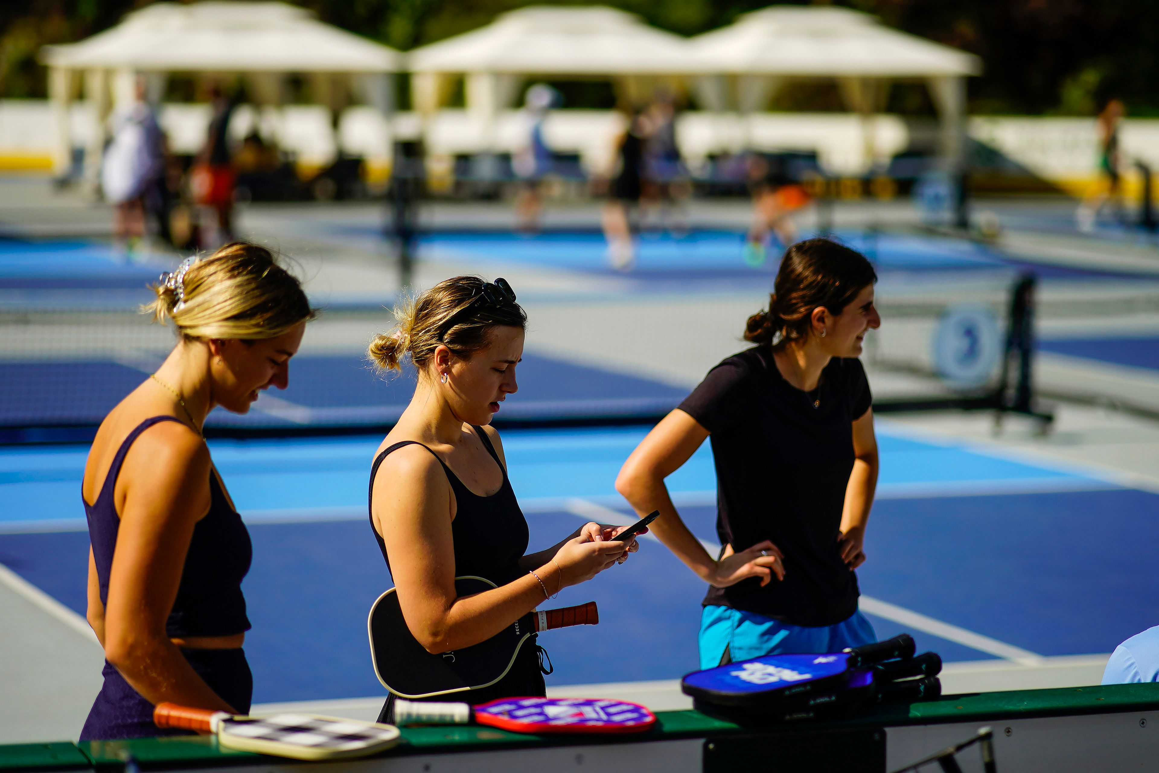 Women wait for friends to practice pickleball on the courts of CityPickle at Central Park's Wollman Rink, Saturday, Aug. 24, 2024, in New York. (AP Photo/Eduardo Munoz Alvarez)