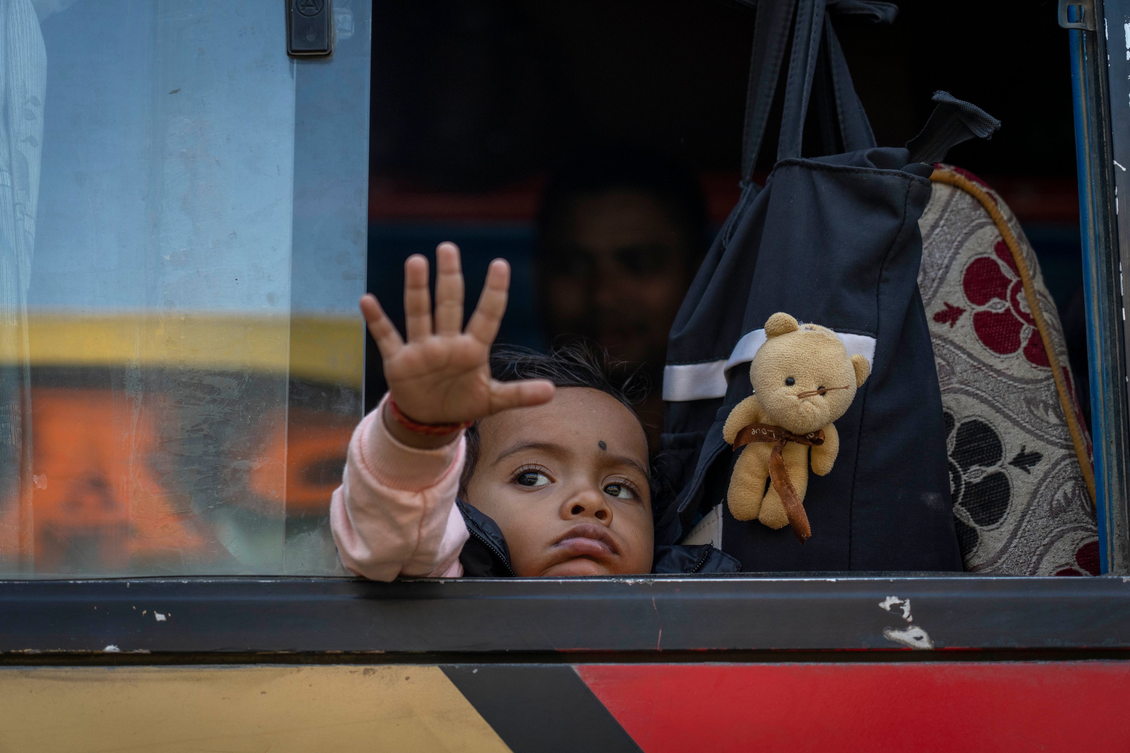 A young boy plays as he and his parents wait for bus to board for their journey home to celebrate the Dashain festival in Kathmandu, Nepal, Thursday, Oct. 10, 2024. Dashain, the most important religious festival of Nepal's Hindus, commemorates the victory of the Gods over demons. (AP Photo/Niranjan Shrestha)