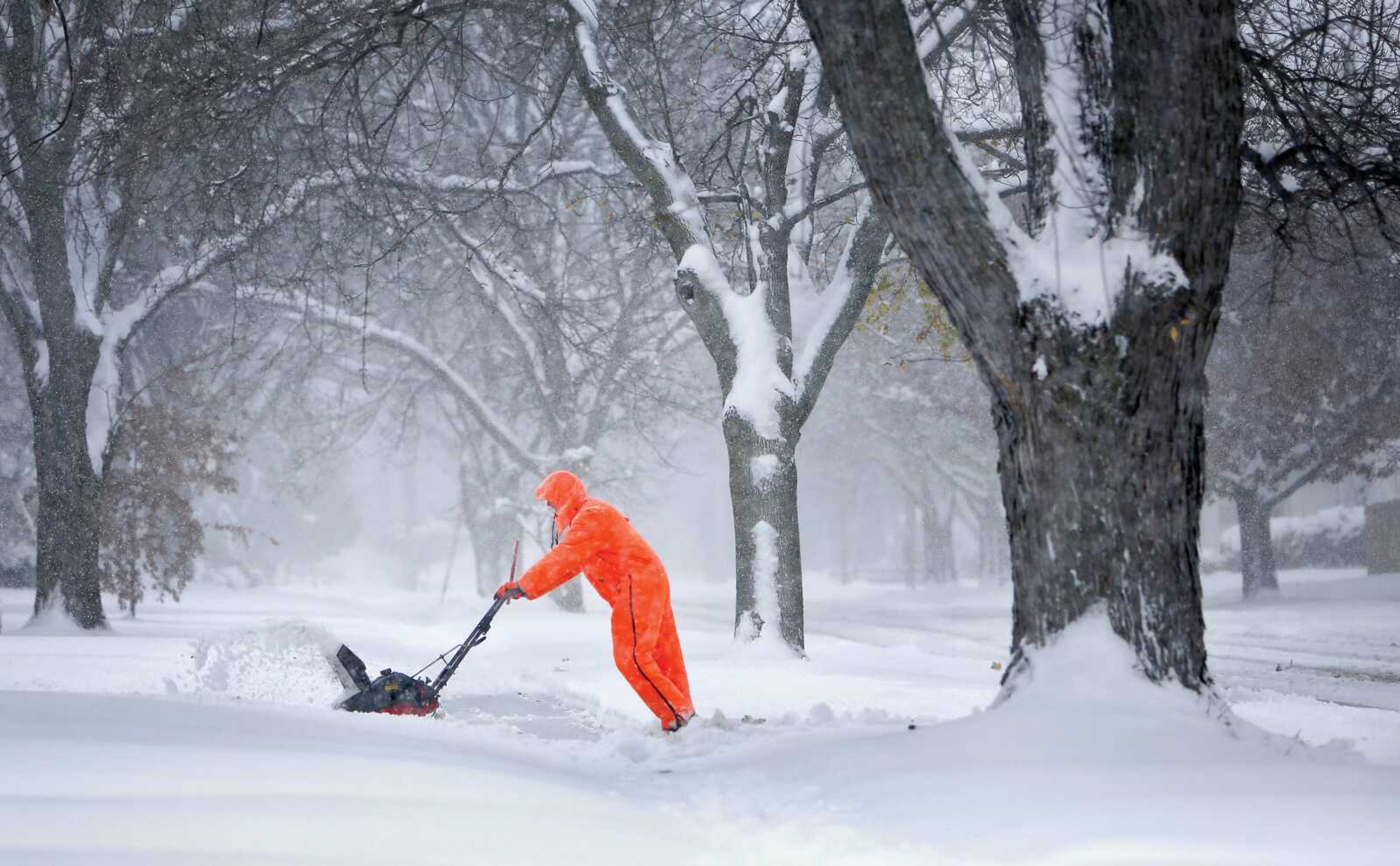 Gary Miller clears his neighbor's driveway Saturday after a snowstorm in Janesville, Wisconsin. (Anthony Wahl ~ The Janesville Gazette via AP)