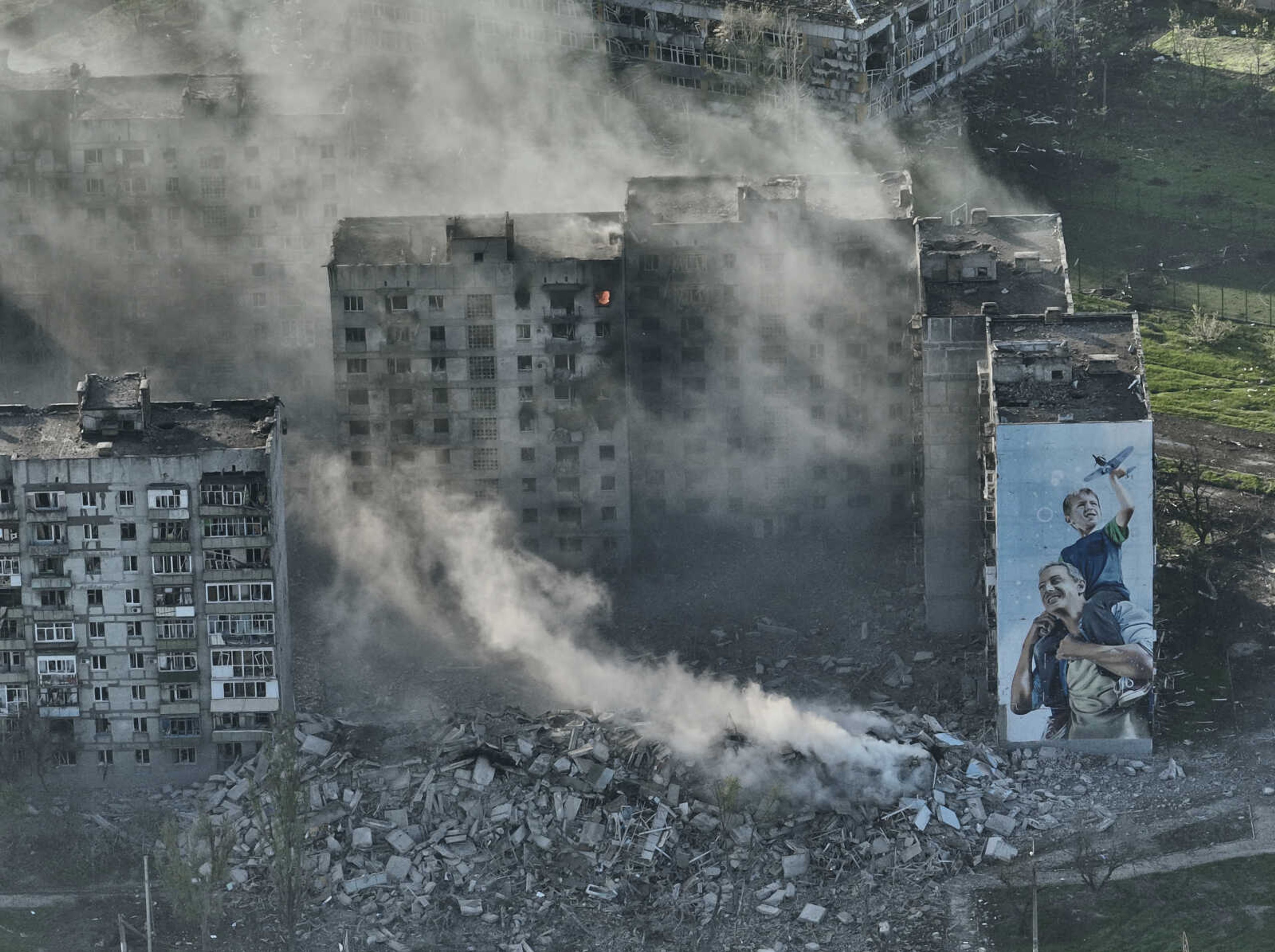 Smoke rises from a building in Bakhmut, the site of the heaviest battles with the Russian troops in the Donetsk region, Ukraine, Wednesday, April 26, 2023. (AP Photo/Libkos)