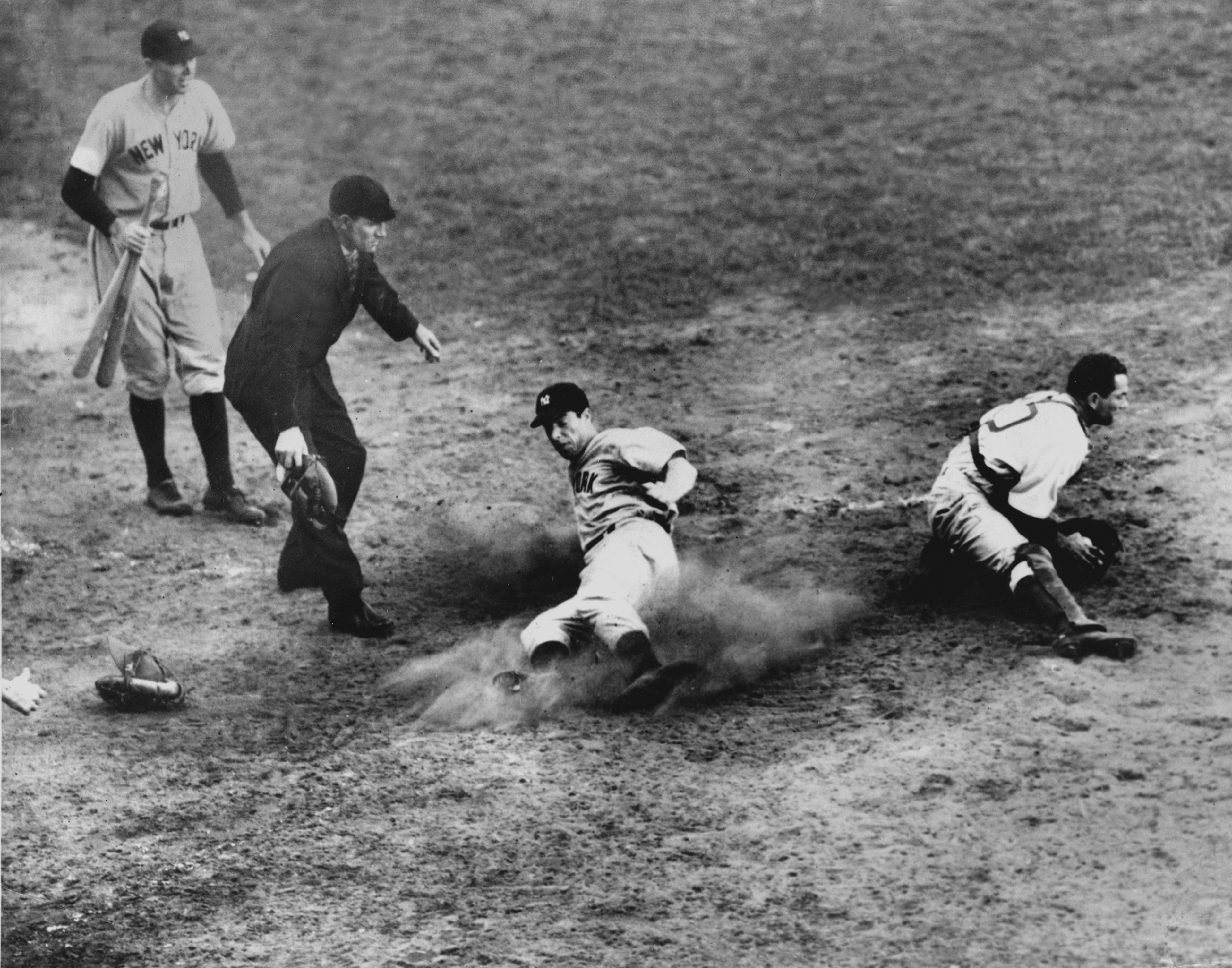 FILE - New York Yankees outfielder Joe DiMaggio (5) slides home safely in the ninth inning to score his team's fifth and winning run in Game 4 of the World Series against the Brooklyn Dodgers at Ebbets Field, Brooklyn, N.Y., Oct. 5, 1941. Dodgers catcher Mickey Owen has the ball. The Yankees won 7 to 4. (AP Photo/Murray Becker, File)