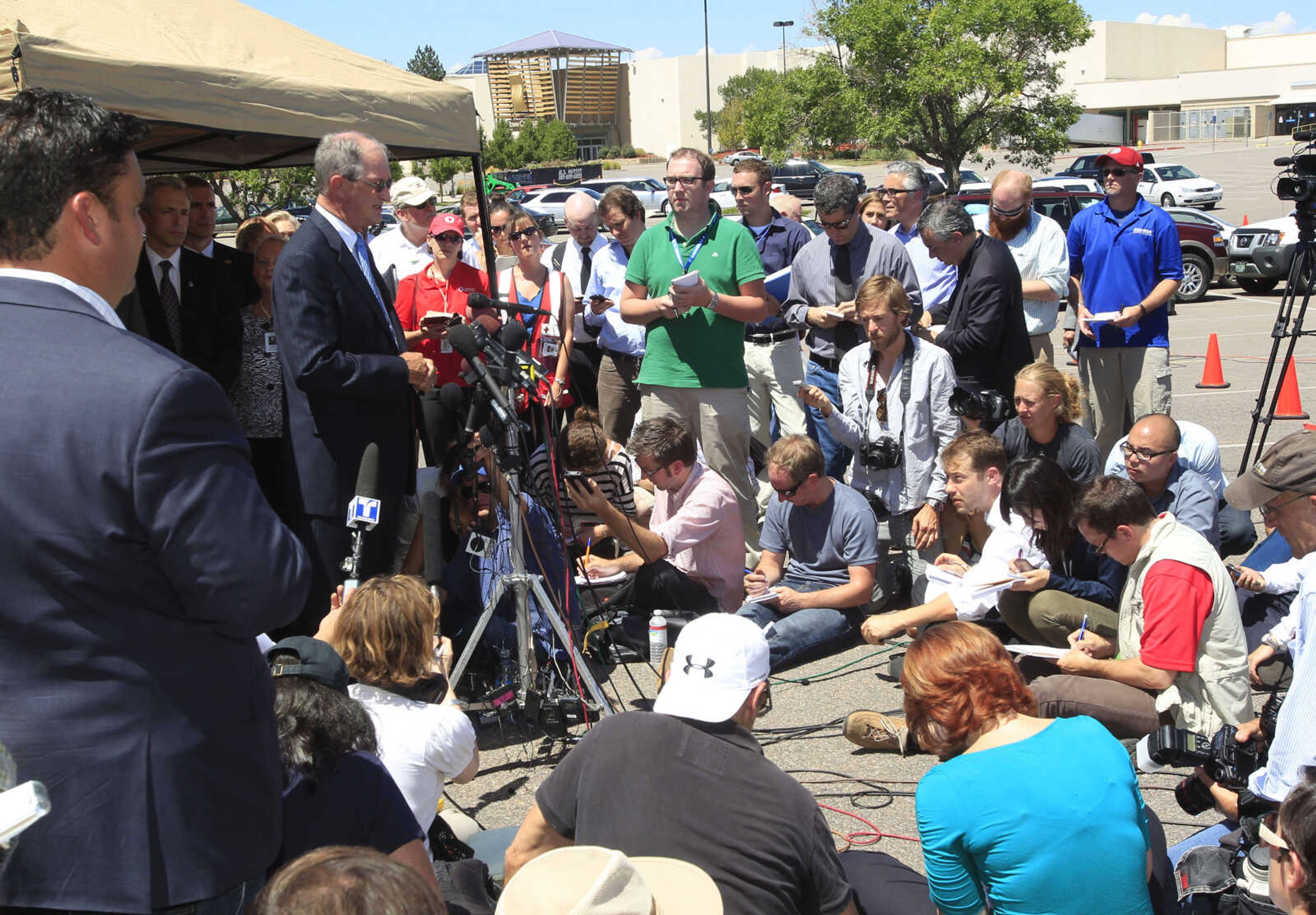 Steve Hogan, left center, mayor of Aurora, Colo., talks to reporters during a news conference at the Century 16 theatre east of the Aurora Mall in Aurora, Colo., on Friday, July 20, 2012.  A gunman in a gas mask hurled a gas canister and opened fire in the sold-out theater during a midnight showing of the new Batman movie Friday, killing 12 people and injuring 59 in one of the deadliest mass shootings in recent U.S. history. The shooter was arrested shortly after the attack, and law enforcement officials identified him as 24-year-old James Holmes. (AP Photo/David Zalubowski)