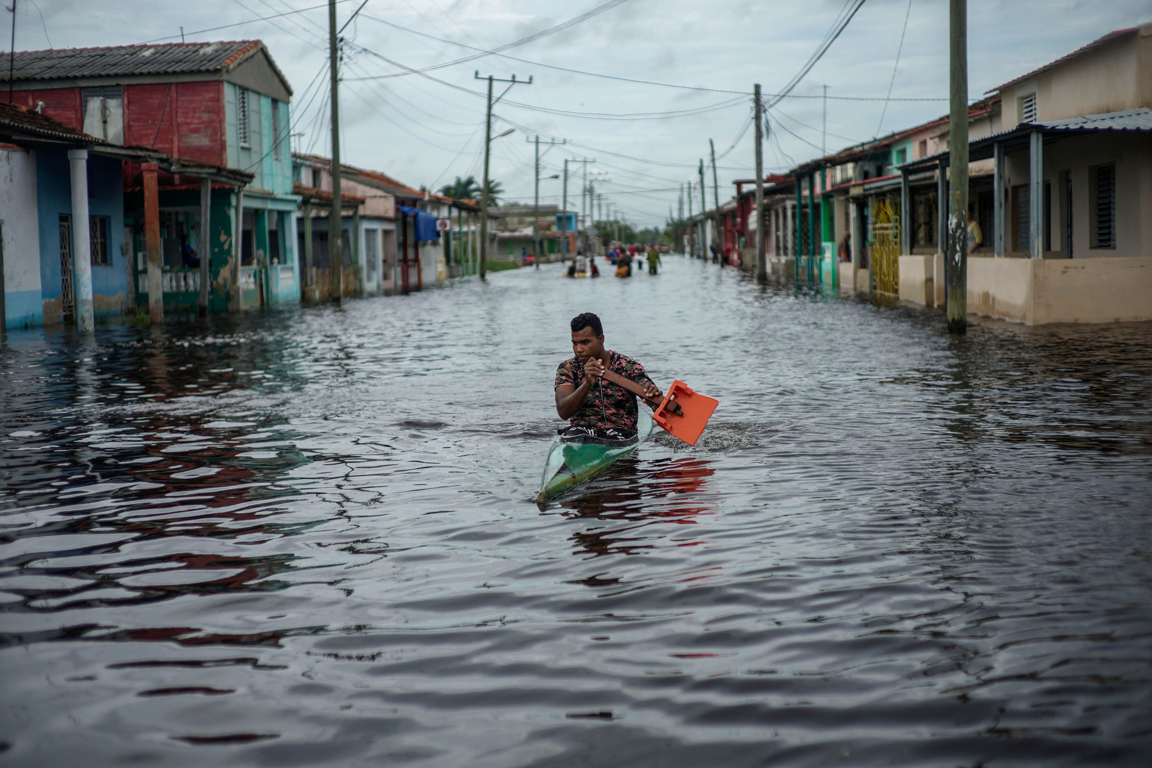 A man in a kayak uses a makeshift paddle as he travels through a street flooded in the passing of Hurricane Helene, in Batabano, Mayabeque province, Cuba, Thursday, Sept. 26, 2024. (AP Photo/Ramon Espinosa)