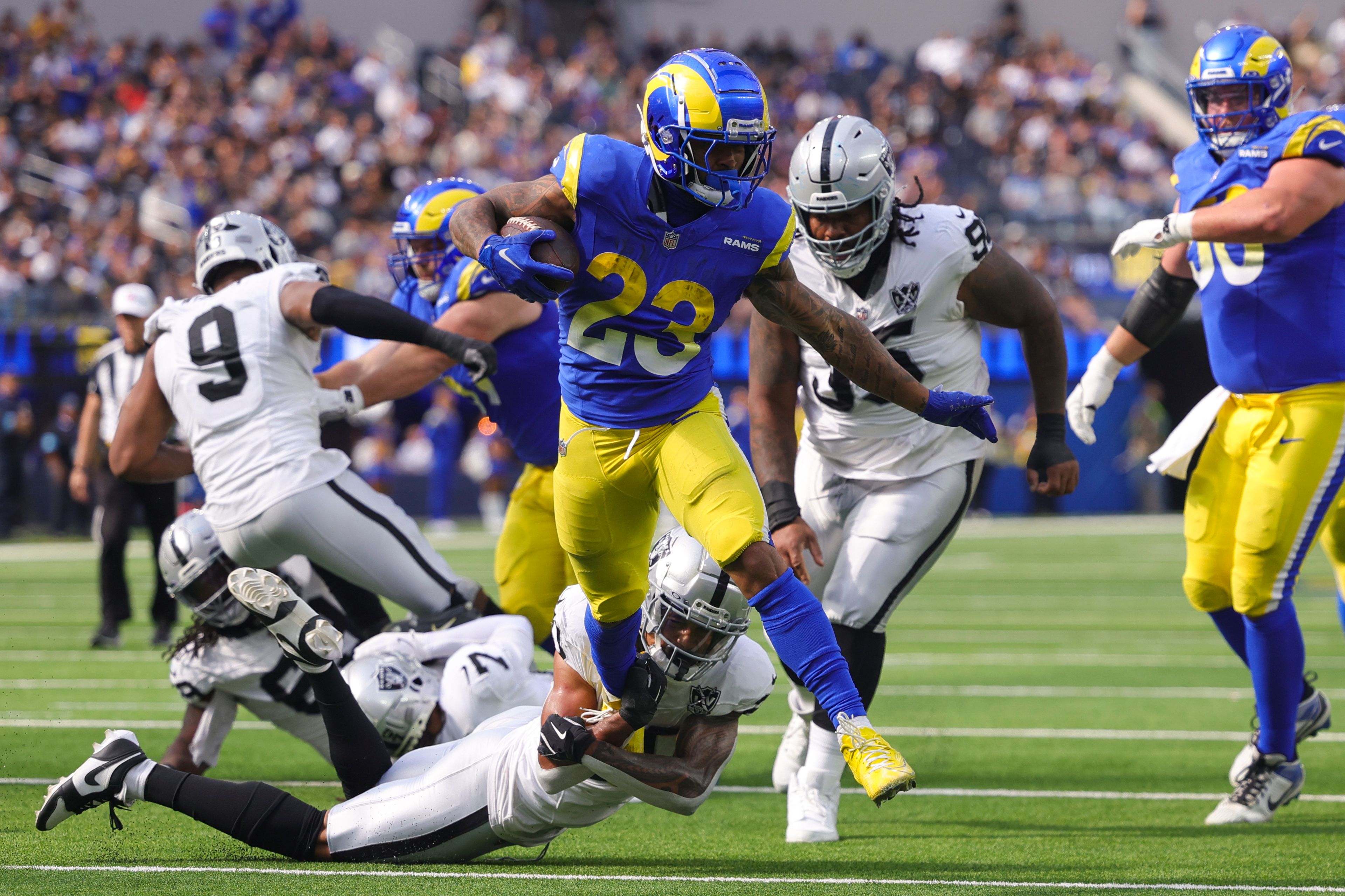 Los Angeles Rams running back Kyren Williams (23) runs for a touchdown as Las Vegas Raiders safety Isaiah Pola-Mao, bottom, attempts to tackle during the first half of an NFL football game against the Las Vegas Raiders, Sunday, Oct. 20, 2024, in Inglewood, Calif. (AP Photo/Ryan Sun)