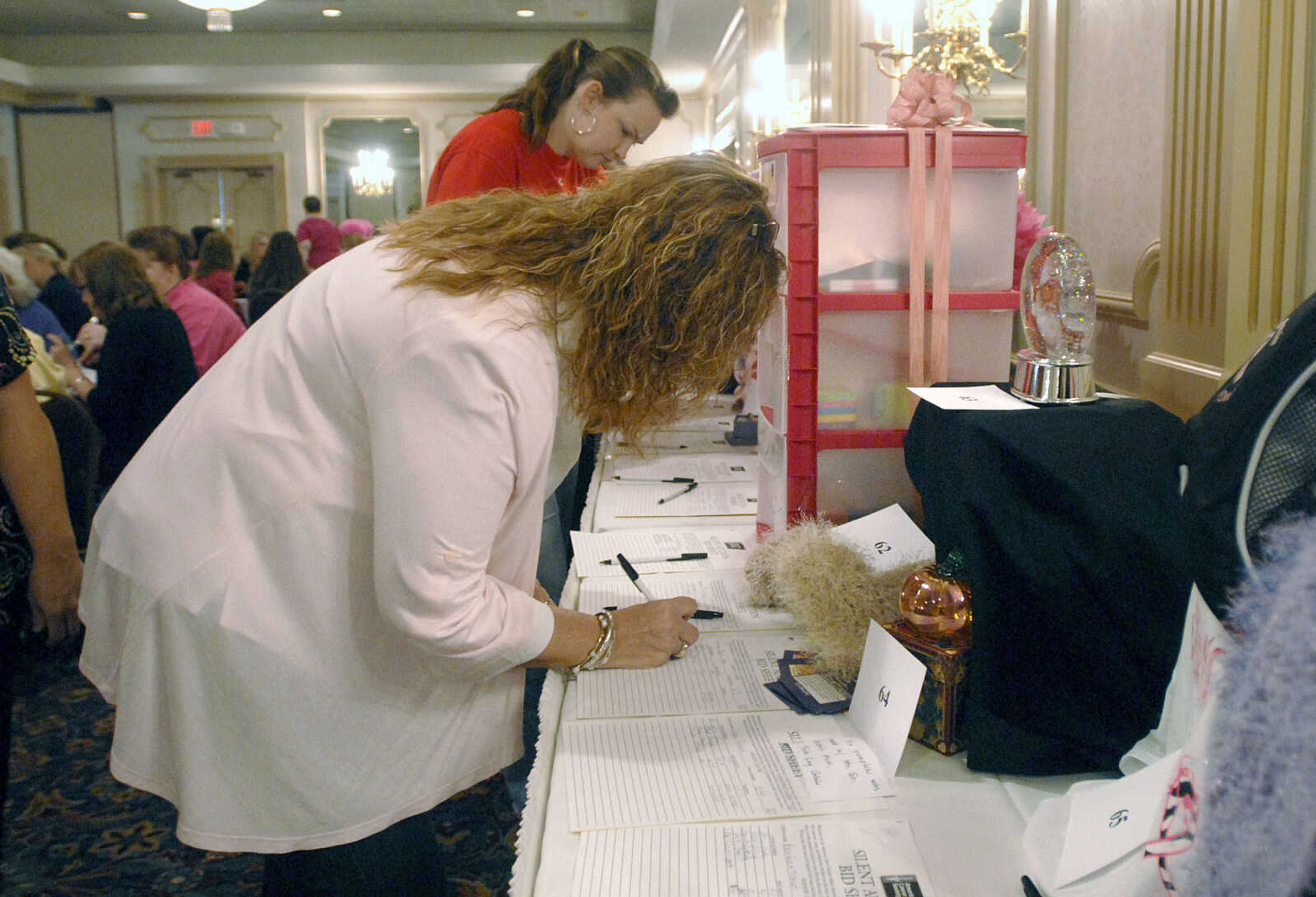 LAURA SIMON ~ lsimon@semissourian.com
People put down bids on silent auction items during the 8th annual American Cancer Society Pink Ribbon Luncheon Wednesday, October 12, 2011 at Drury Lodge in Cape Girardeau. The luncheon featured a silent auction, live purse auction, speakers Lisa howe, Julie Metzger, Priscilla Mabuse and Lori Faire. All proceeds of the luncheon benefit cancer patients in southeast Missouri through the American Cancer Society's Cape Area Patient Service Fund.