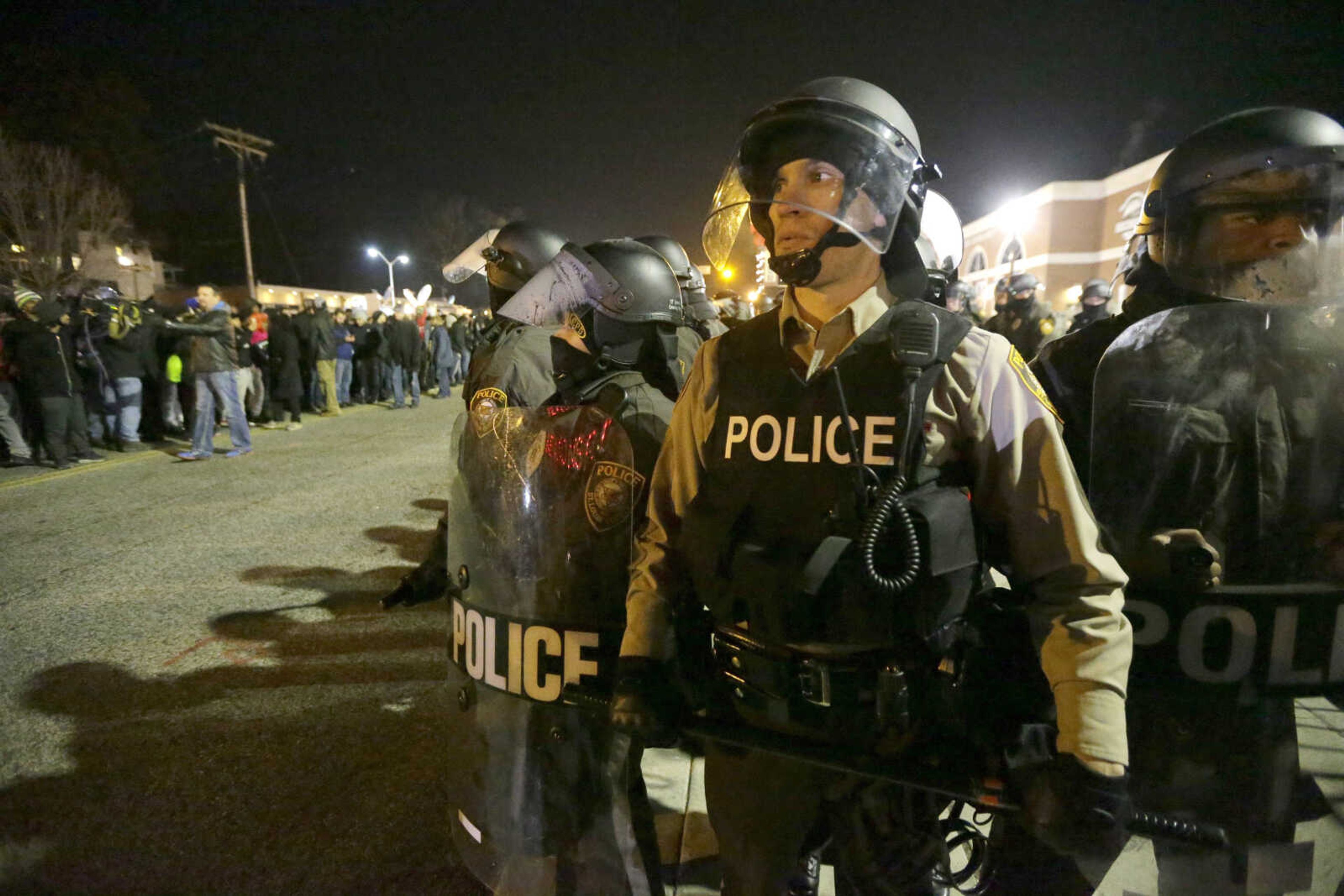 Police watch the street as protesters gather Tuesday in Ferguson, Missouri. (Charlie Riedel ~ Associated Press file)