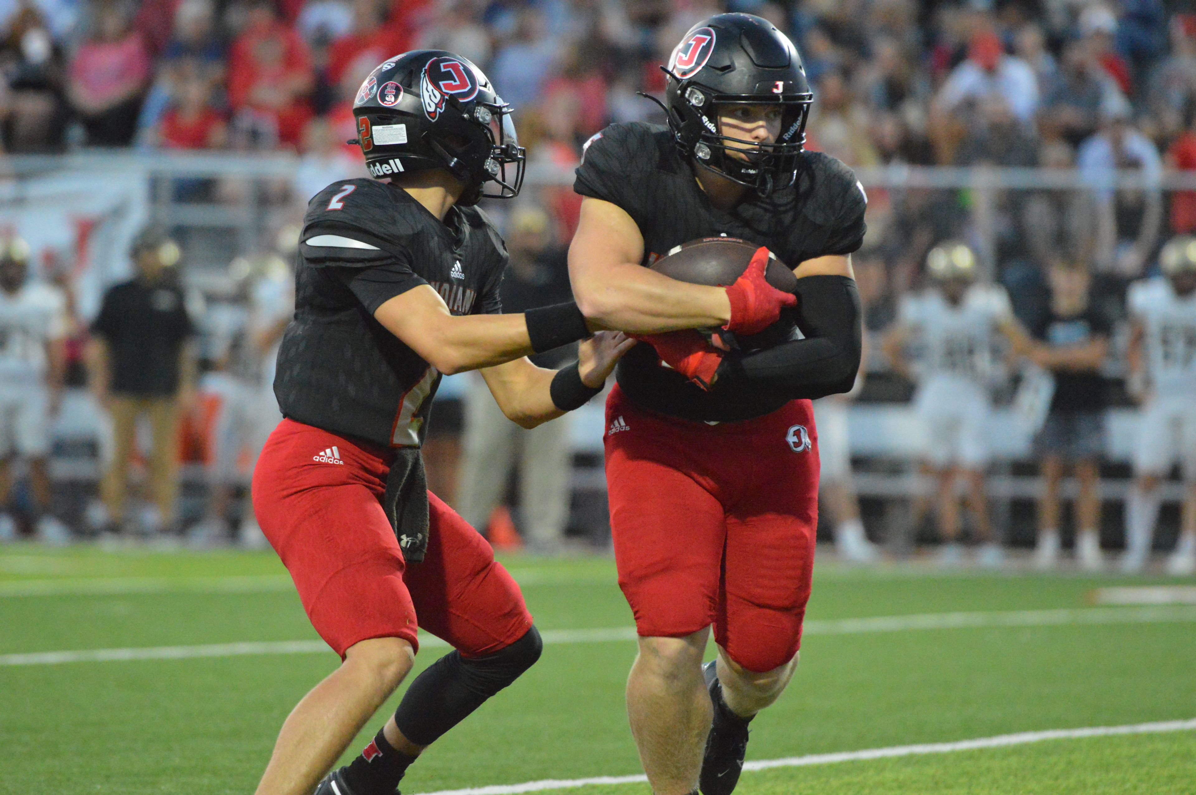 Jackson quarterback Drew Parsons hands it off to running back Zach Crump in the first quarter against Farmington on Friday, Sept. 20.