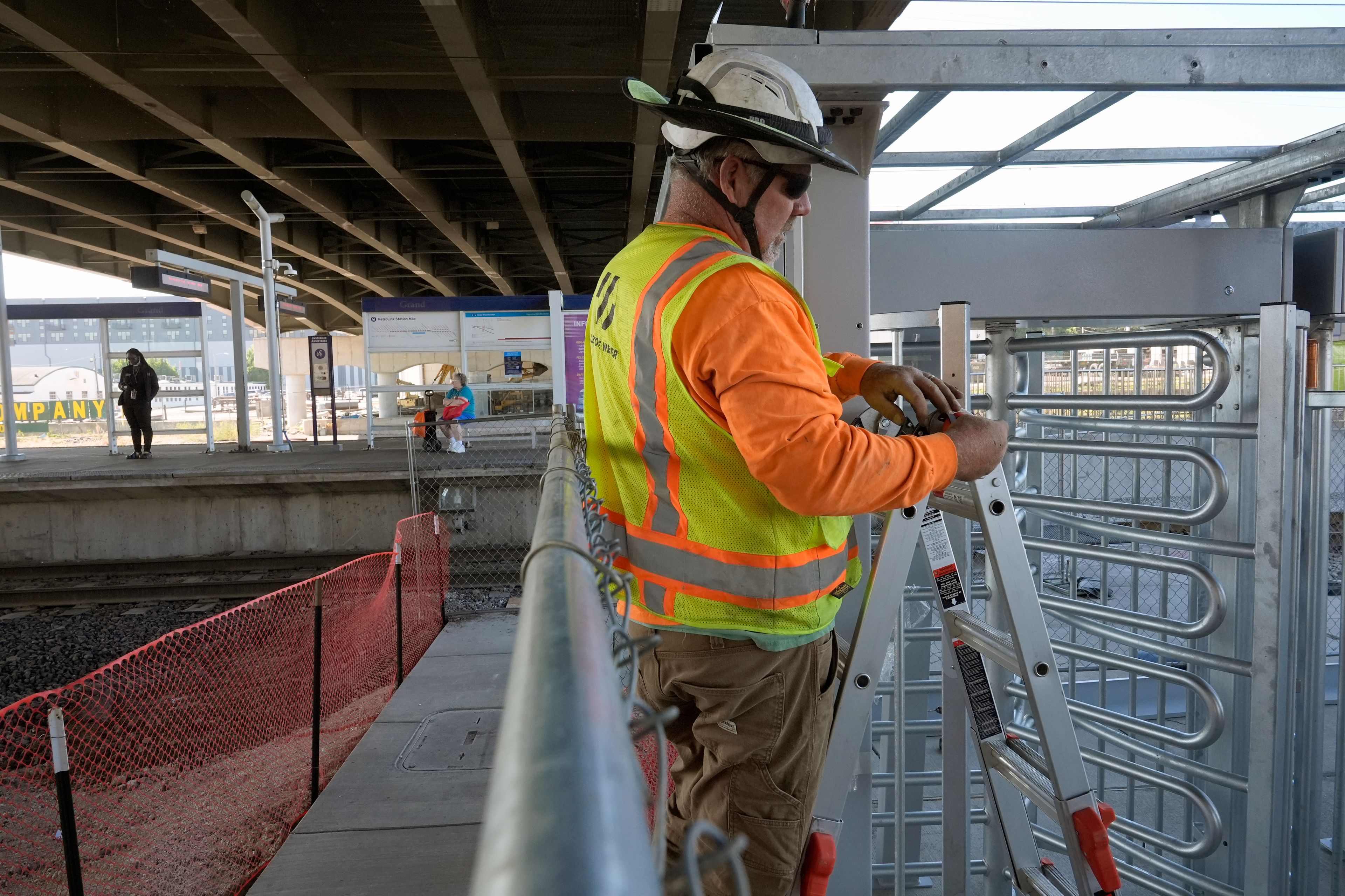 Gary Baalman with Millstone Weber construction works to install metal a gate that will prevent customers from entering a MetroLink platform without a valid fare card Wednesday, Oct. 9, 2024, in St. Louis. (AP Photo/Jeff Roberson)