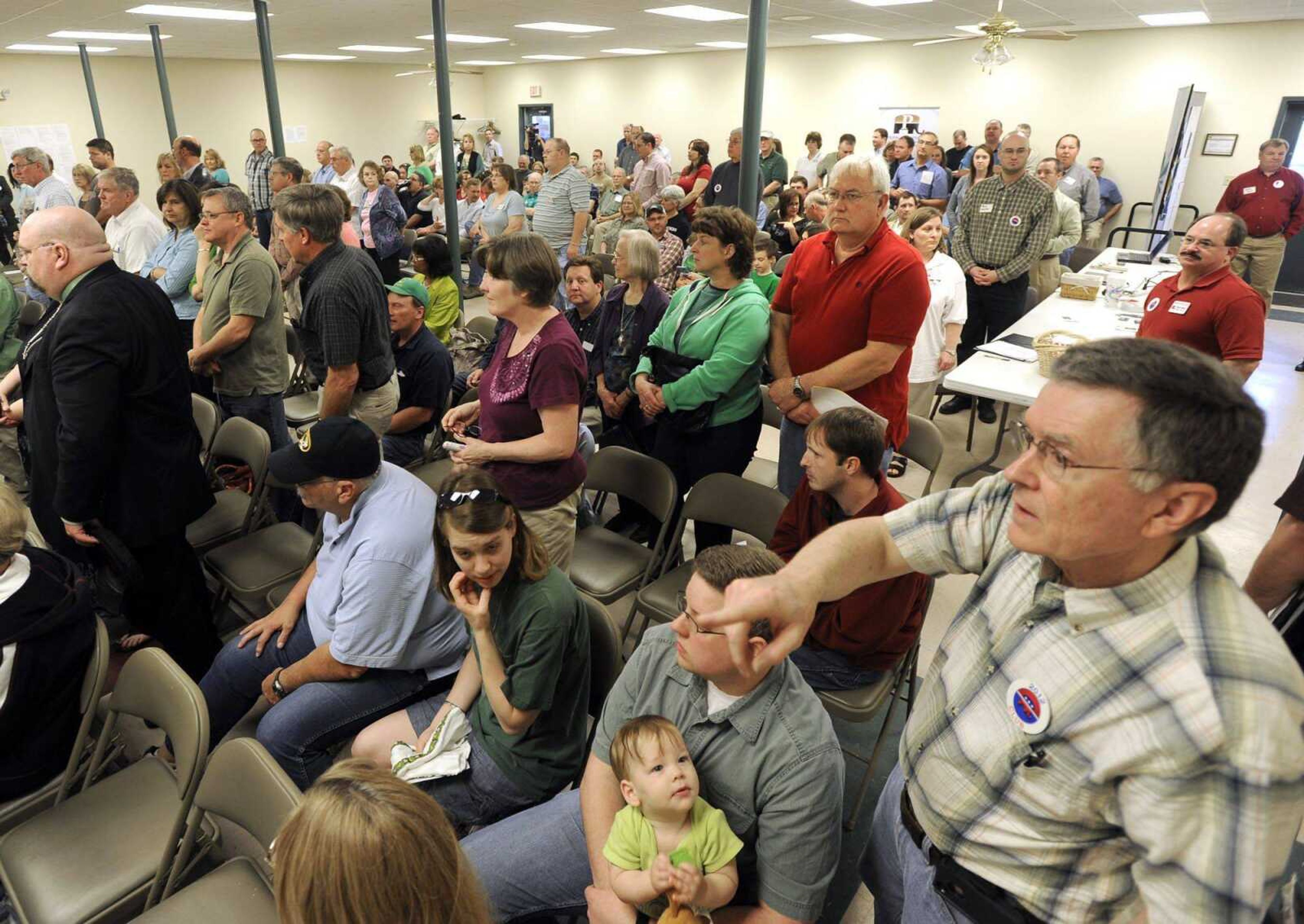 Fritz Sander counts the people standing to vote for Evan Trump as Cape Girardeau County GOP caucus chairman Saturday in Jackson. (Fred Lynch)