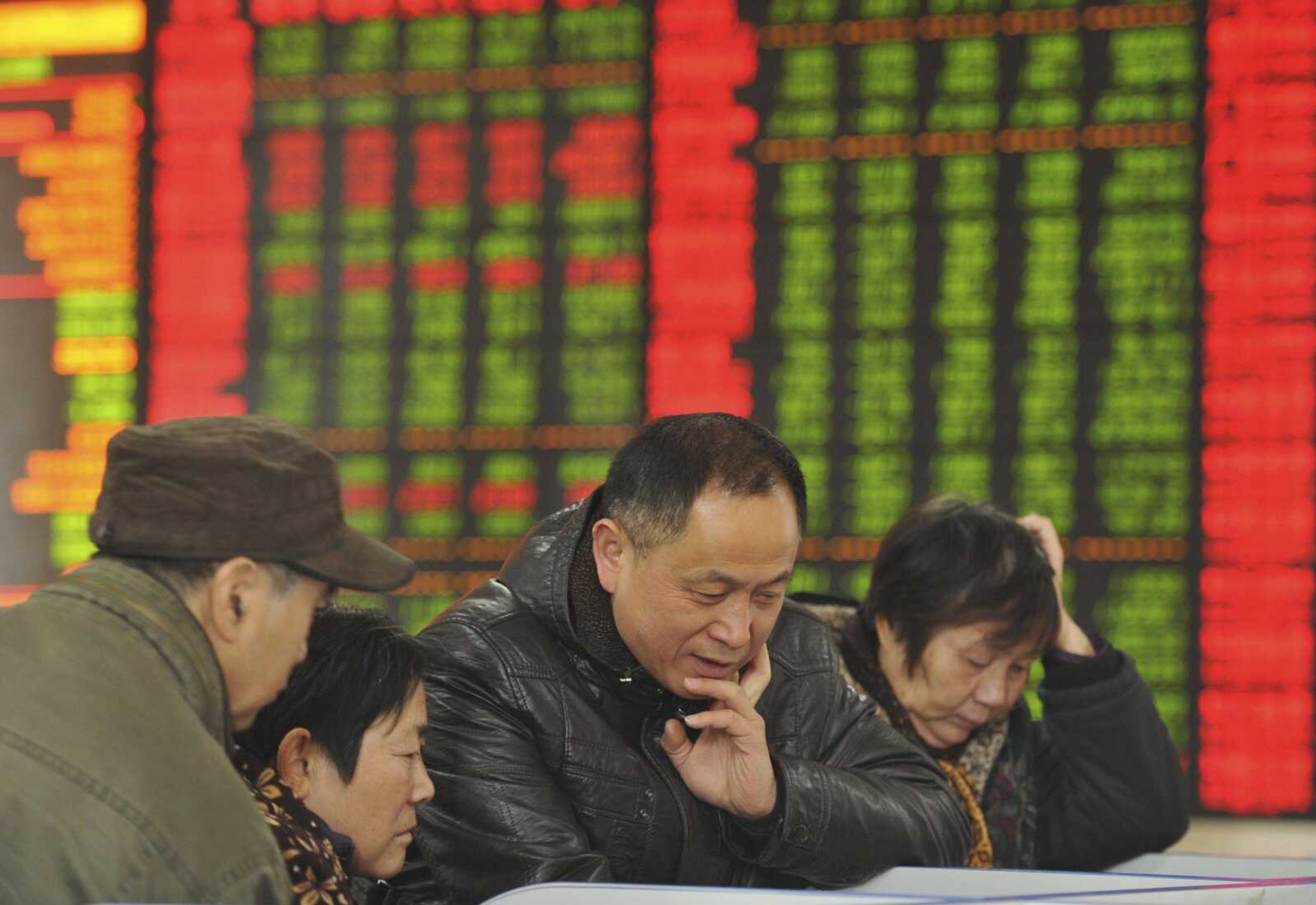 Chinese investors monitor stock prices at a brokerage house Nov. 27 in Fuyang in central China's Anhui province. China's economic slowdown and its surprise decision to devalue its currency squeezed emerging economies, roiled financial markets and escalated fears about the global economy were one of The Associated Press' top stories in 2015. (Chinatopix via AP)