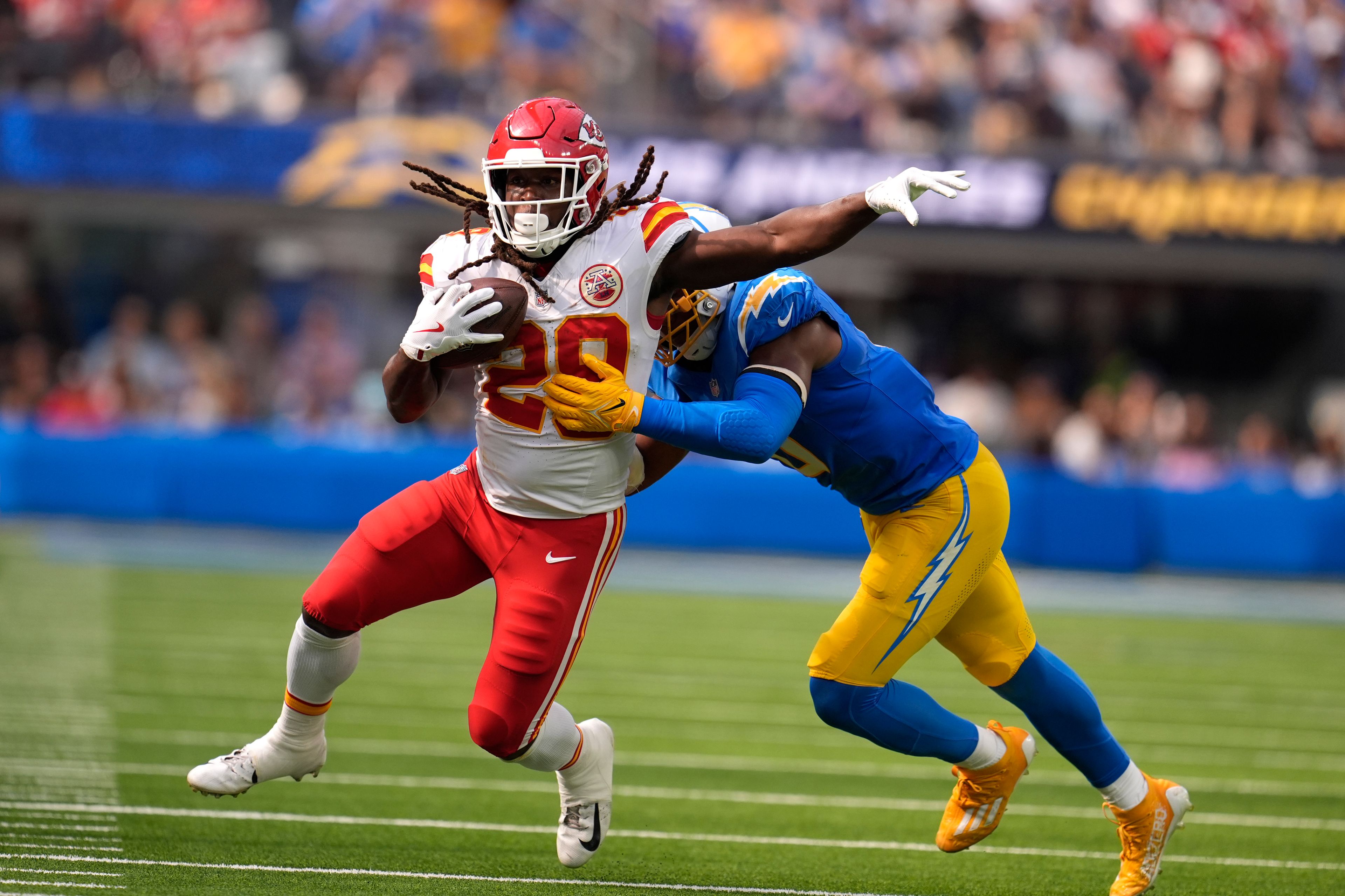 Kansas City Chiefs running back Kareem Hunt (29) runs with the ball as Los Angeles Chargers linebacker Daiyan Henley defends during the second half of an NFL football game Sunday, Sept. 29, 2024, in Inglewood, Calif. (AP Photo/Marcio Jose Sanchez)