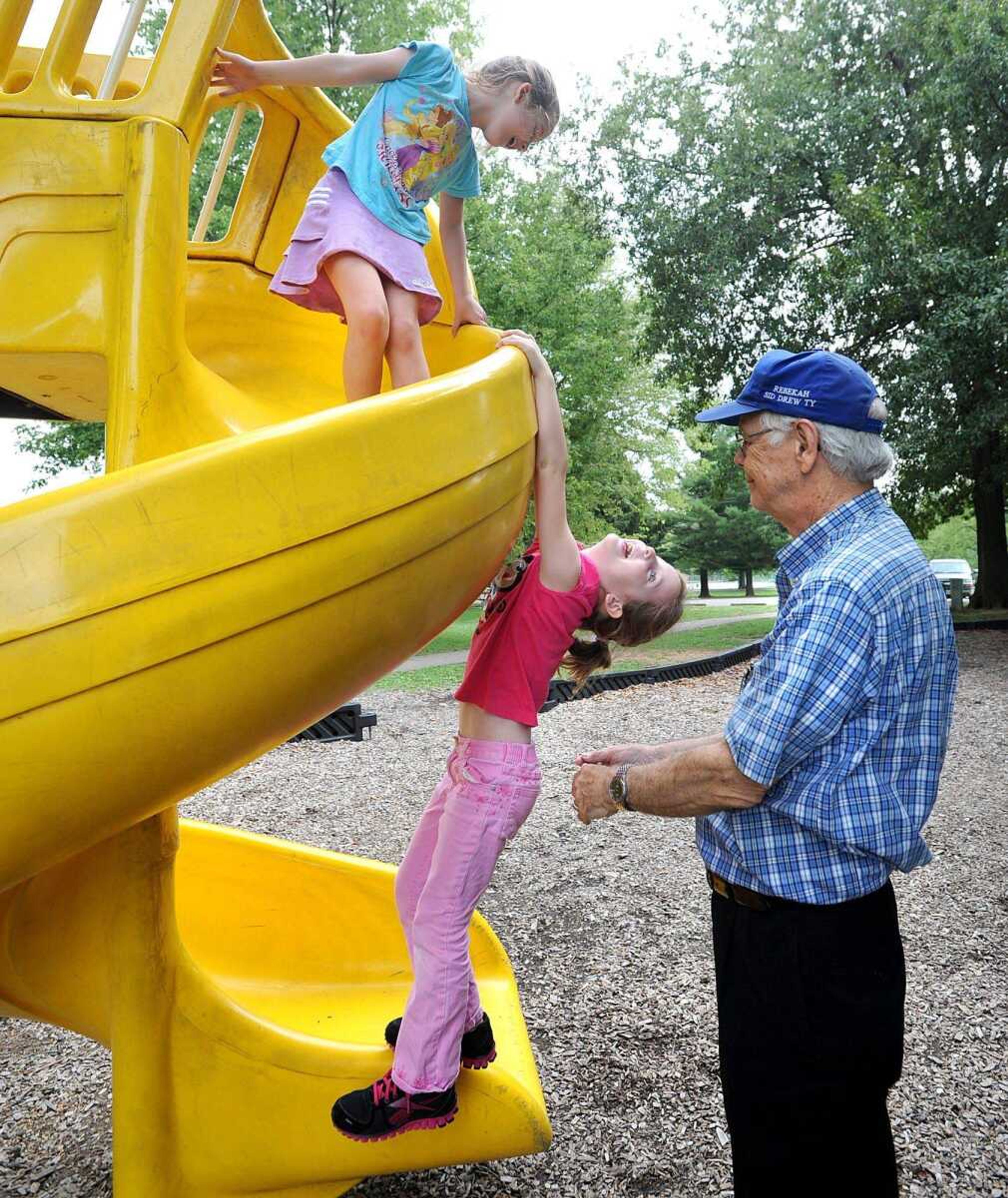 Howard Reynolds of Lexington, Ky., supervises his twin granddaughters Rebekah, bottom, and Rachel Moran as they play on the slide Monday afternoon at Jackson City Park. (Laura Simon)