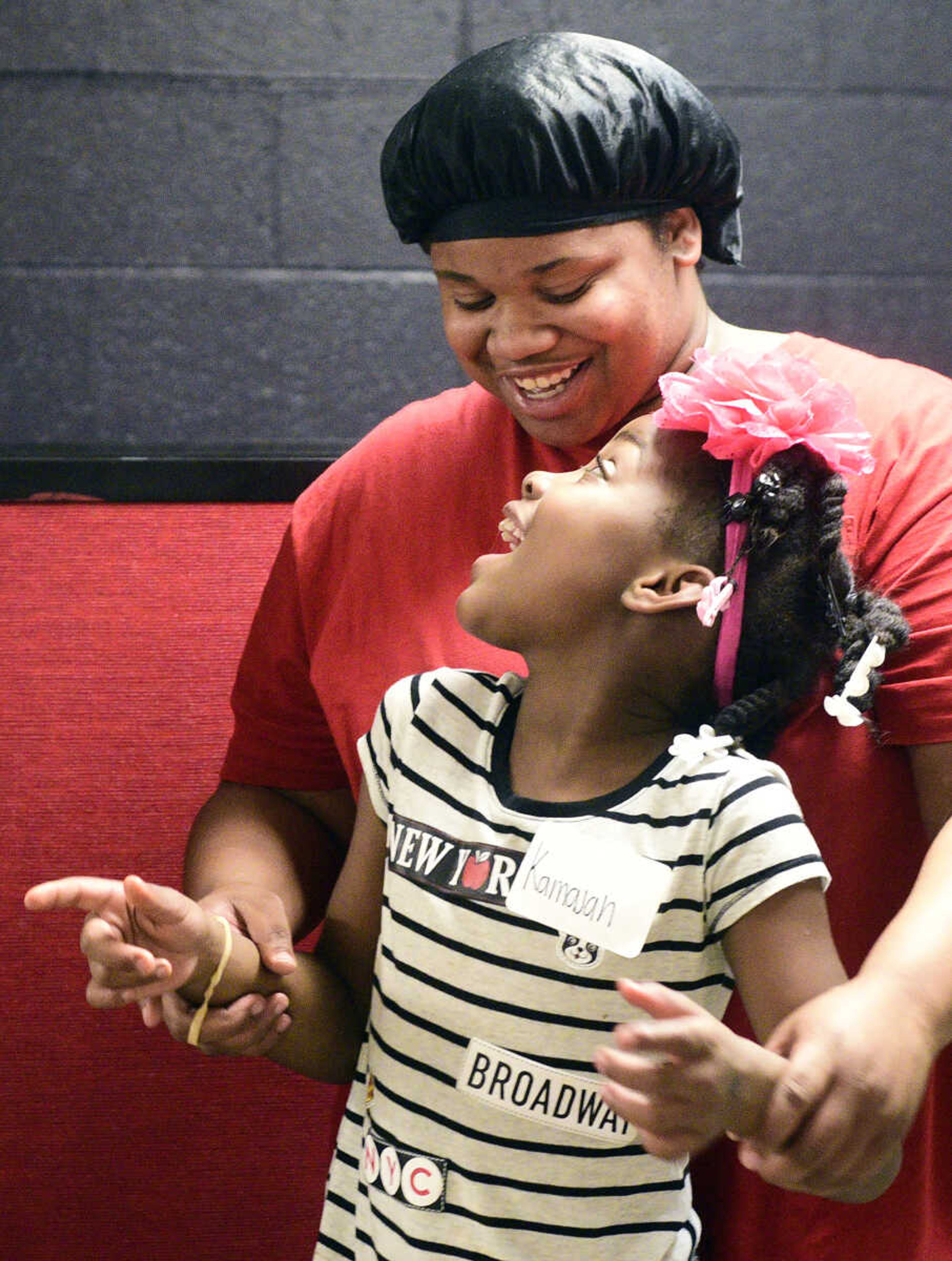 Kamajah Hamilton looks up at Chamika Moore as they dance together on Monday, Aug. 14, 2017, during the Salvation Army's after school program at The Bridge Outreach Center in Cape Girardeau.