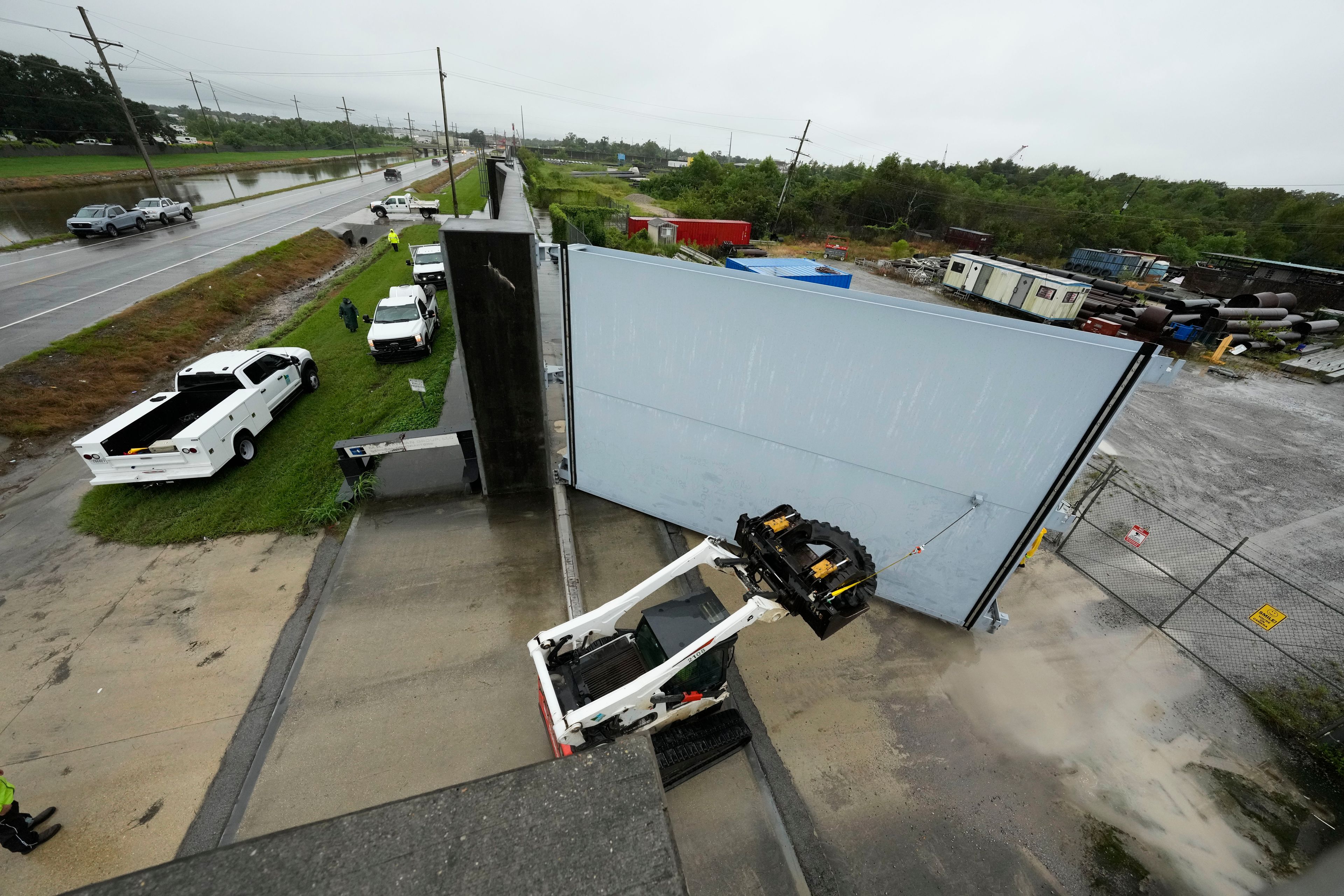 Workers from the Southeast Louisiana Flood Protection Authority-West close floodgates along the Harvey Canal, just outside the New Orleans city limits, in anticipation of Tropical Storm Francine, in Harvey, La., Tuesday, Sept. 10, 2024. (AP Photo/Gerald Herbert)