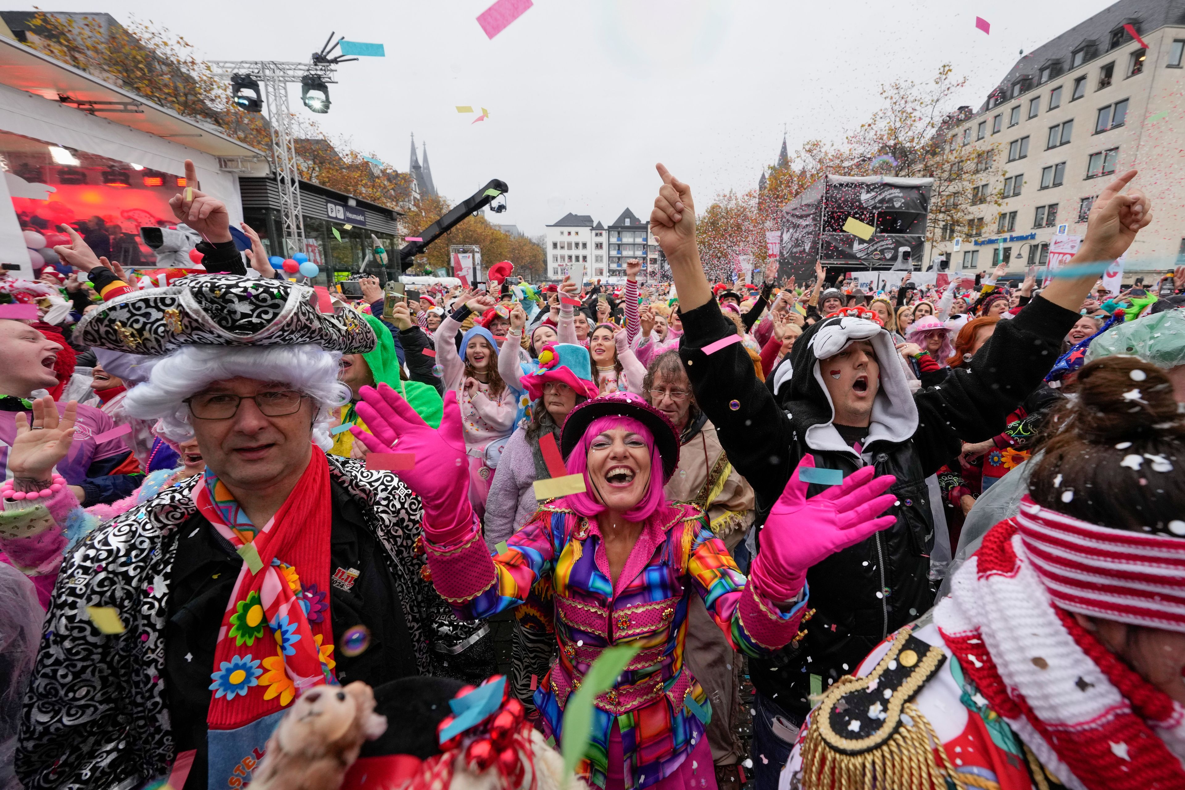 Costumed revelers celebrate at the central Heumarkt while tens of thousands of carnival fools take to the streets of Cologne, Germany, Monday, November 11, 2024, heralding the official start of the carnival season. (AP Photo/Martin Meissner)