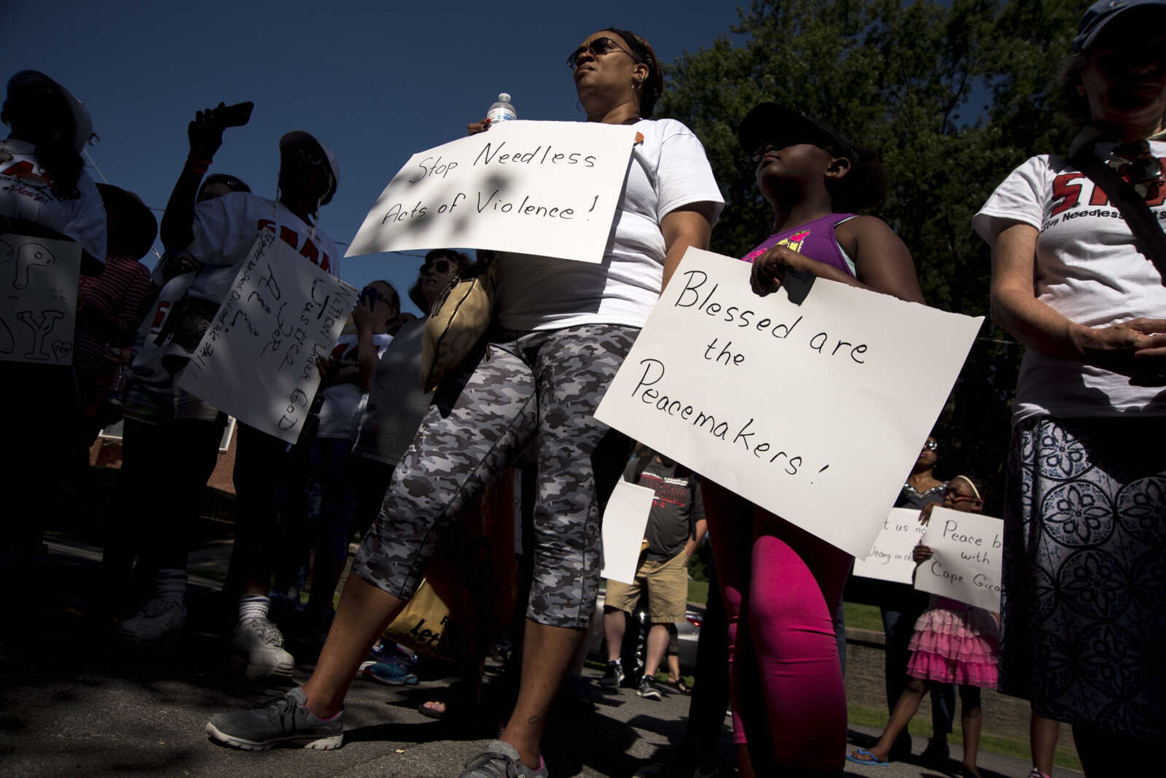 Community members hold signs during a Stop Needless Acts of Violence Please (SNAP) prayer march Saturday, June 10, 2017 in Cape Girardeau.