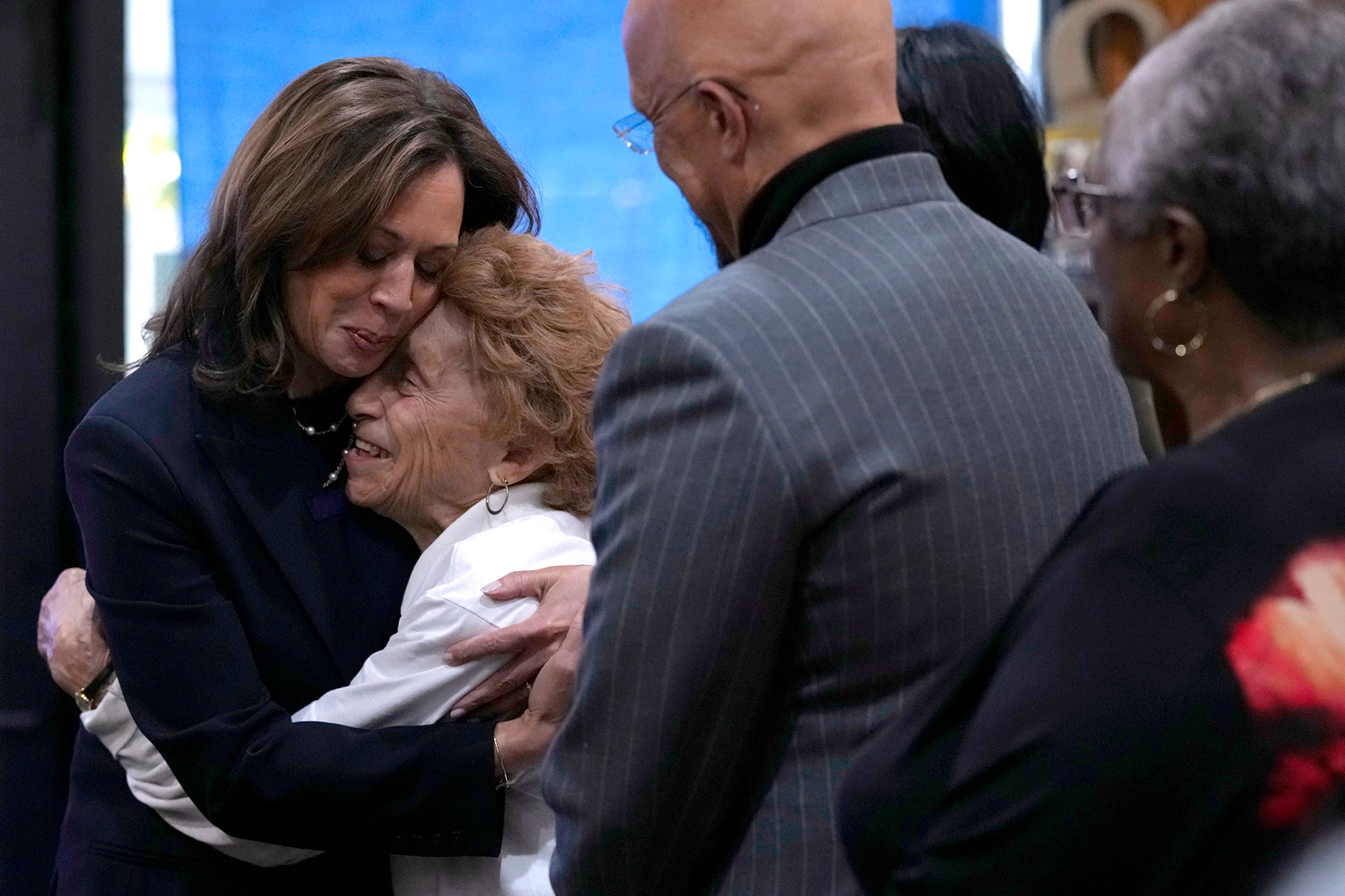 Democratic presidential nominee Vice President Kamala Harris, from left, hugs Ann Hughes as her son State Sen. Vincent Hughes, D-Philadelphia, looks on at Hakim's Bookstore and Gift Shop during a campaign stop, Sunday, Oct. 27, 2024, in Philadelphia. 