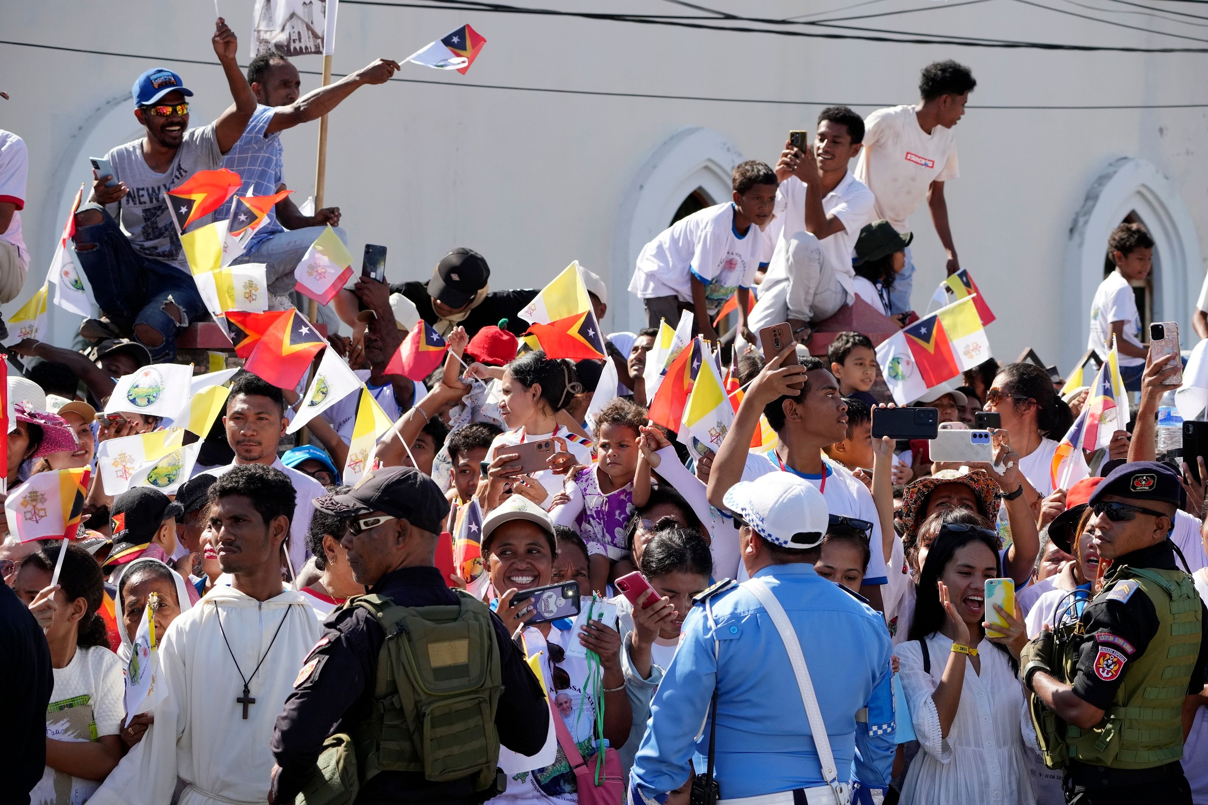 People wait for Pope Francis to arrive at the Cathedral of the Immaculate Conception in Dili, East Timor, Tuesday, Sept. 10, 2024. (AP Photo/Firdia Lisnawati)