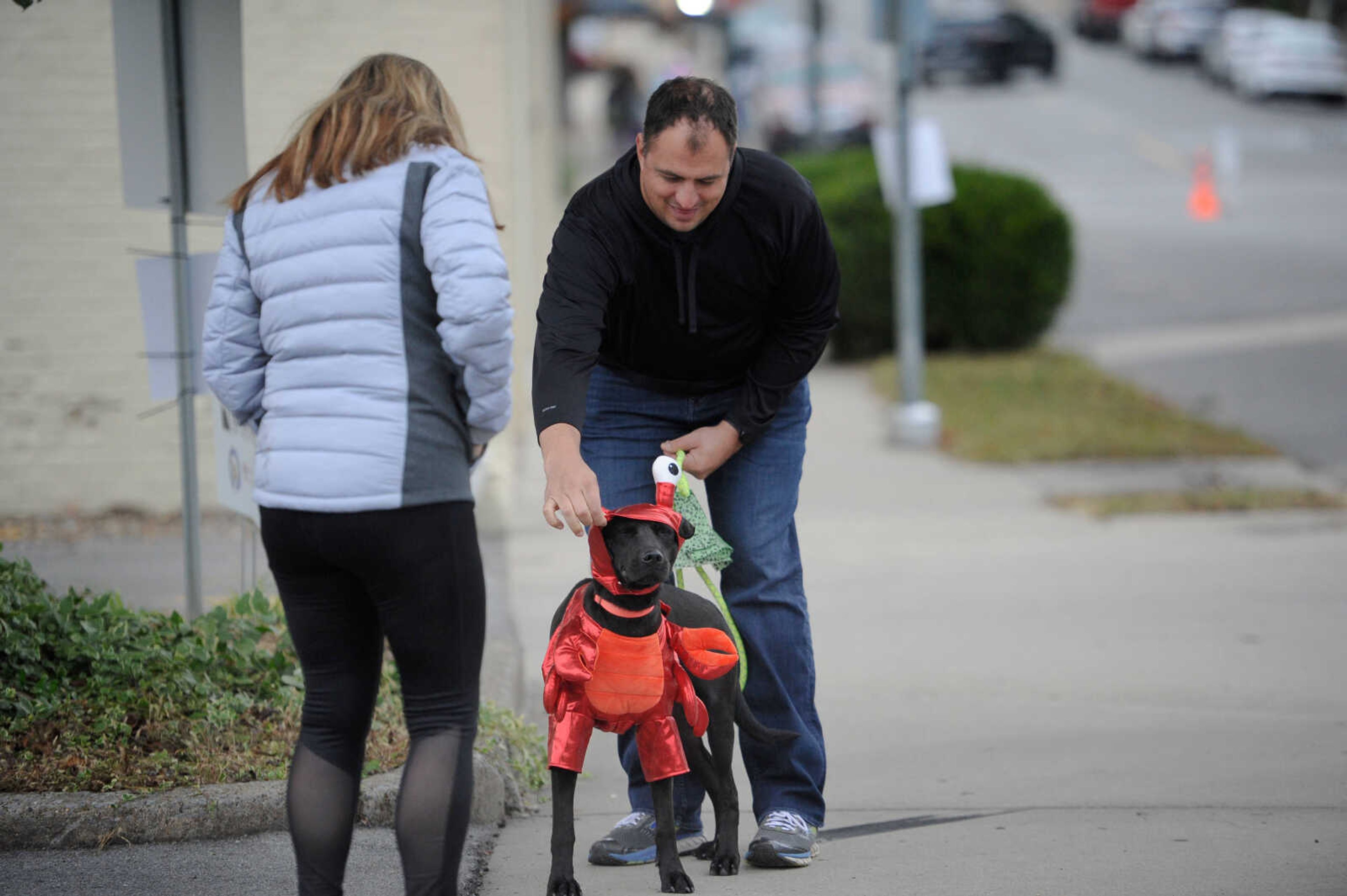 Marc Lumsden adjusts the lobster costume on his foster dog, Rudy, at the Monster Mash Car Bash on Sunday, Oct. 25, 2020. Lumsden said he became a foster parent to Rudy through the Humane Society of Southeast Missouri, where he is still available for adoption.