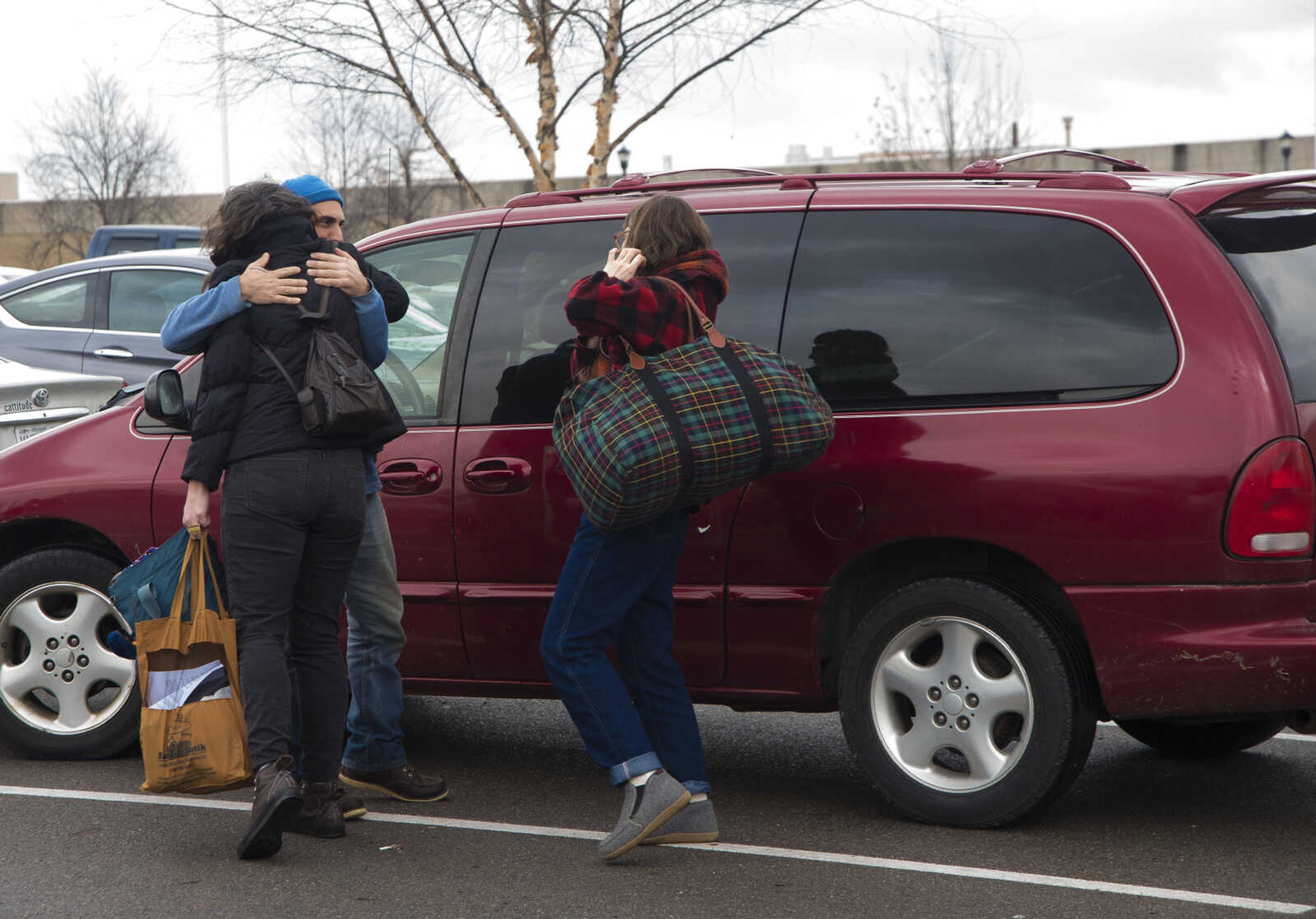 Ross Peterson hugs Lauren Tracy and Emily Scifers before they leave to Washington D.C. for those participating in the Women's March on Saturday as they get ready to leave Friday, Jan. 20, 2017 in the Scully Building parking lot at Southeast Missouri State University in Cape Girardeau.