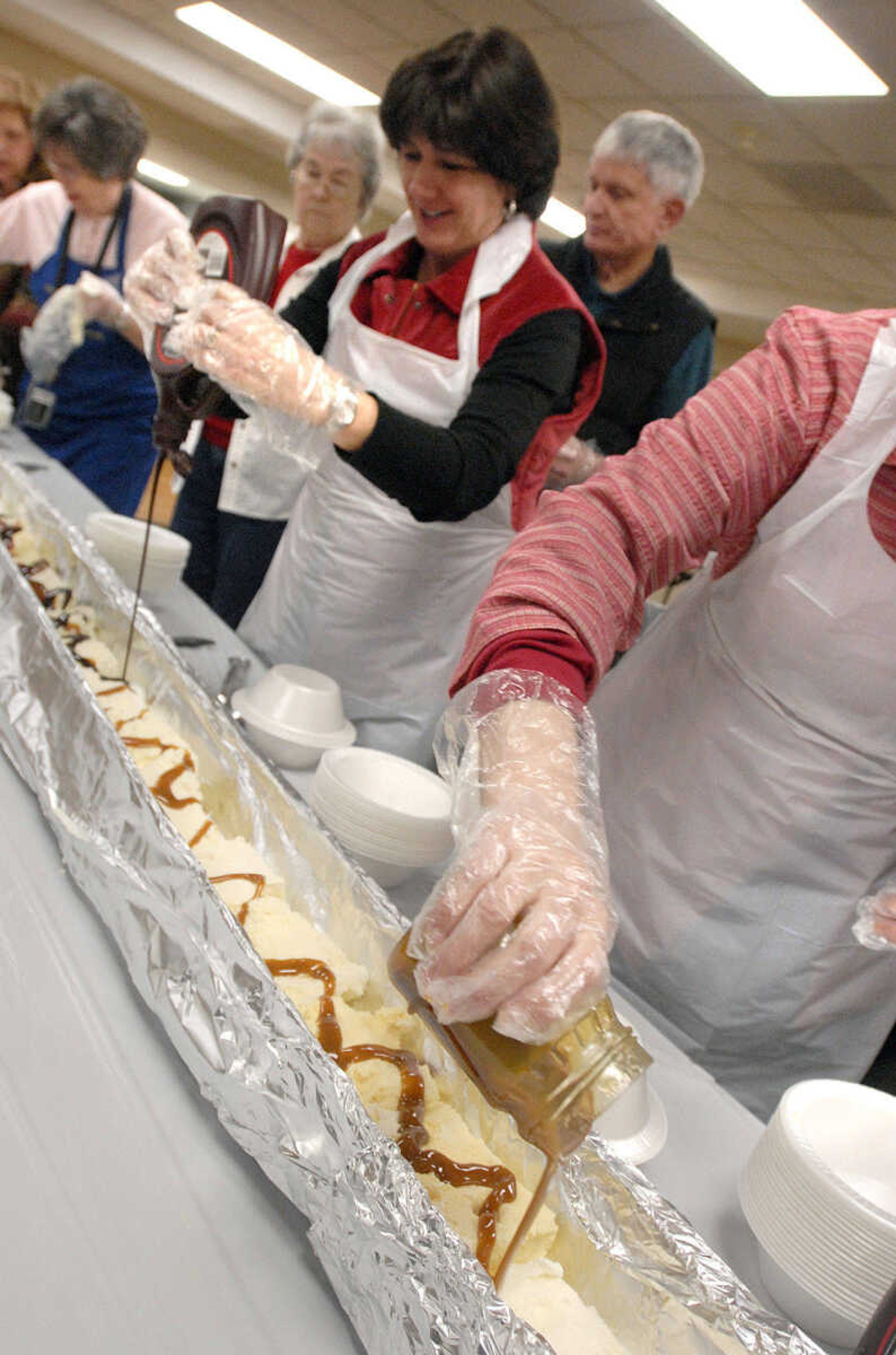 LAURA SIMON ~ lsimon@semissourian.com
Volunteers add chocolate syrup and caramel sauce to the banana split Wednesday afternoon, January 25, 2012 at Lynwood Baptist Church in Cape Girardeau.