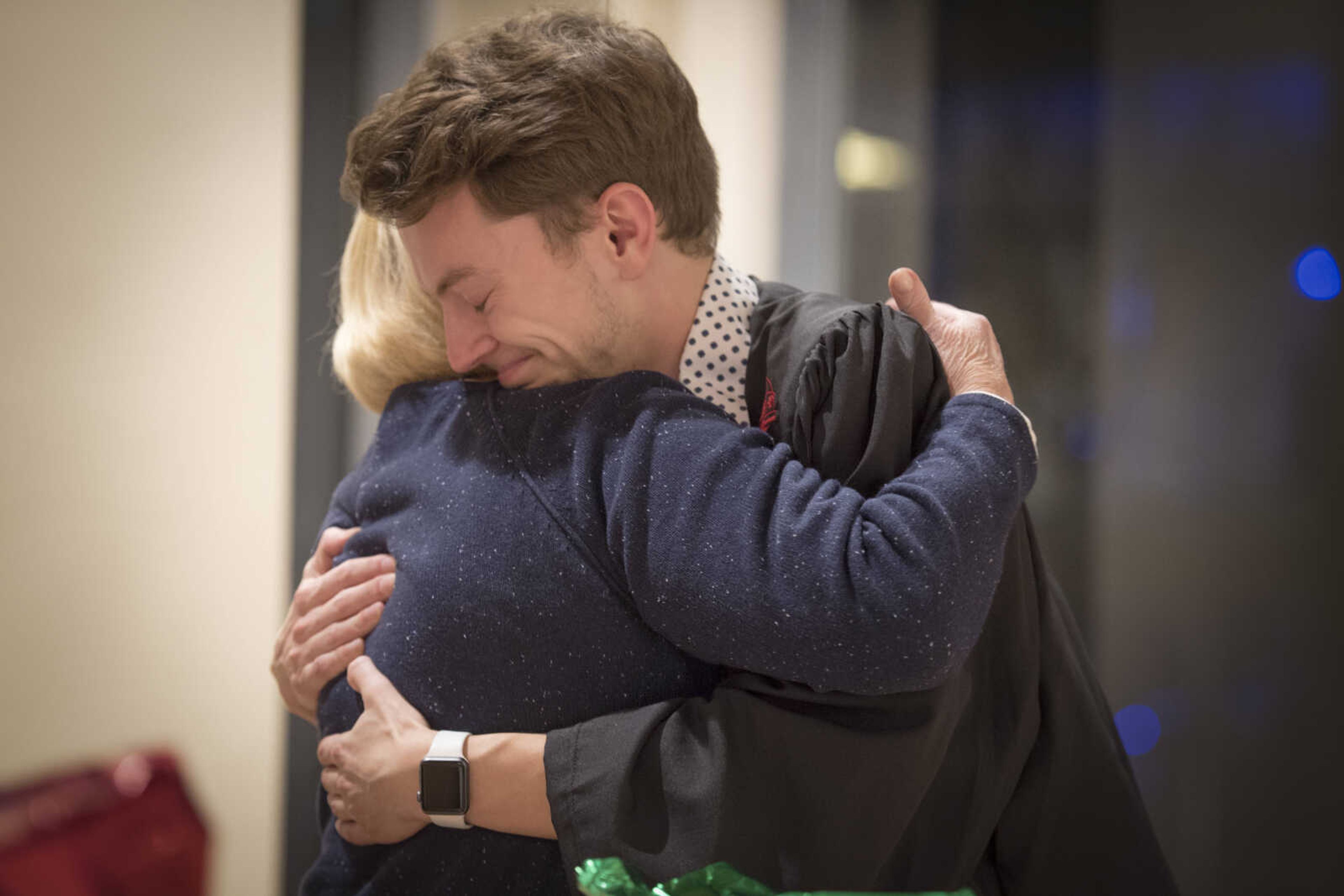 Alex Bargen smiles while hugging Southeast Missouri State mass media administrative assistant Bonnie Gerecke after being adorned with his Kente stole during the inaugural "Donning of the Kente" ceremony Monday, Dec. 9, 2019, at Rust Center for Media, which recognized graduating members of the National Association of Black Journalists at Southeast Missouri State University in Cape Girardeau.