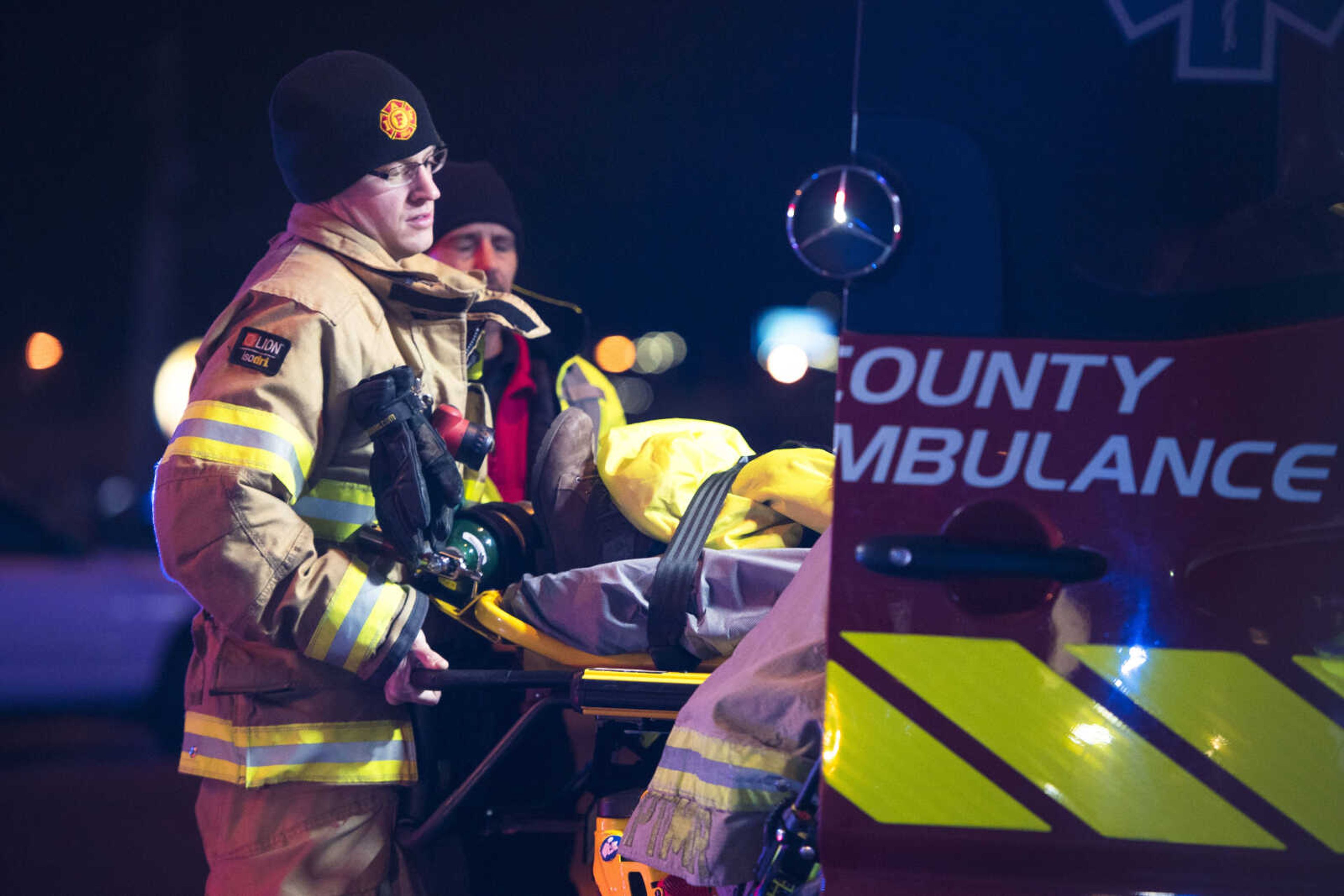 Cape Girardeau firefighter Ethan Essner helps lift a stretcher into a Cape County Private Ambulance after a two-car collision in the intersection of Mount Auburn Road and William Street on Monday, Dec. 9, 2019, in Cape Girardeau.