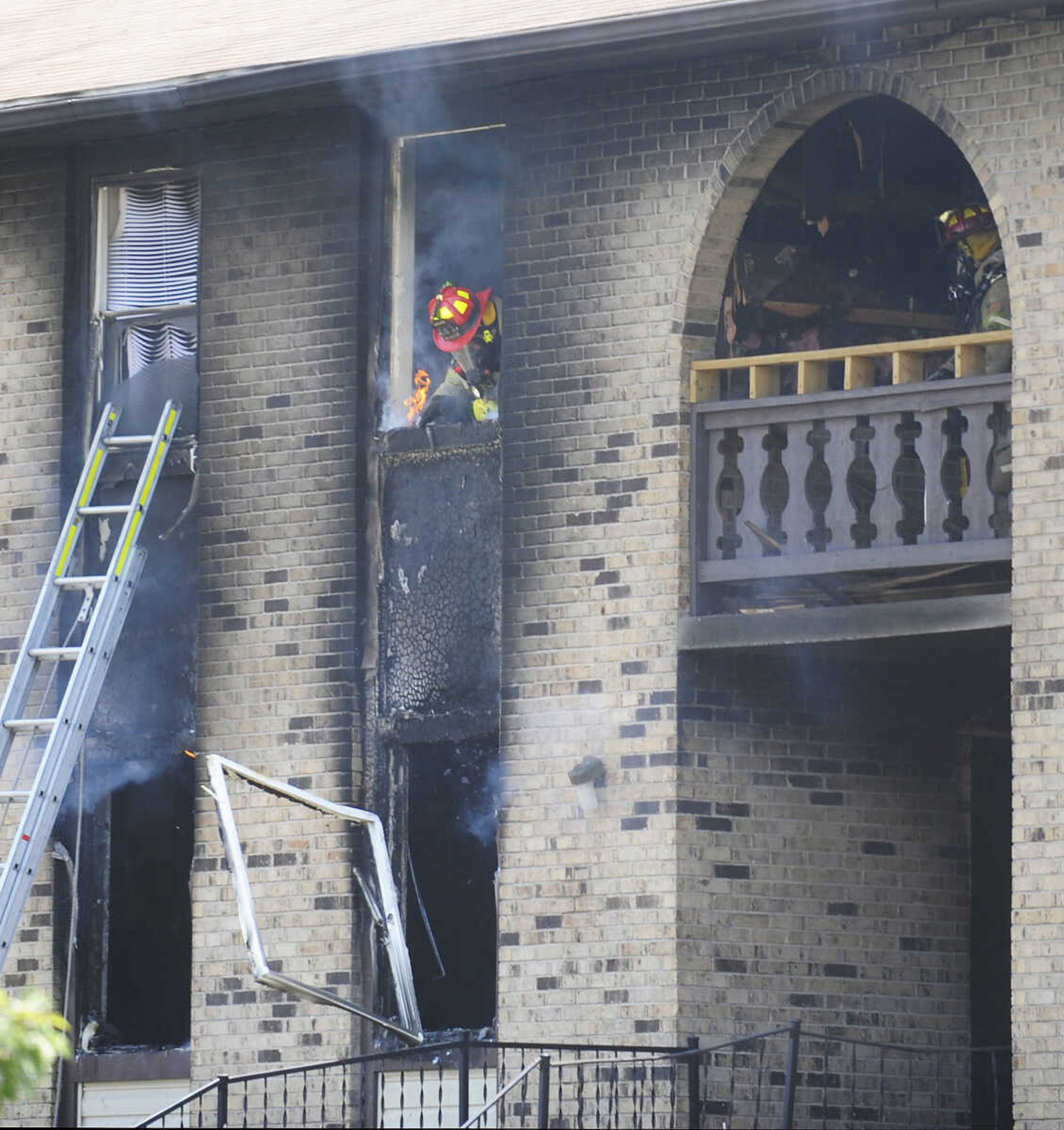 Members of the Cape Girardeau Fire Department work to extinguish a fire Thursday, July 12, in an apartment building at 121 E. Rodney. The fire began in a ground floor unit in building H of the apartment complex and spread to the upper story according to Capt. Ray Warner. The occupant of the upper level unit had to be rescued by fire fighters. The resident of the apartment where the fire began escaped on her own but later asked to be treated for smoke inhalation and was transported to a hospital. (Adam Vogler)