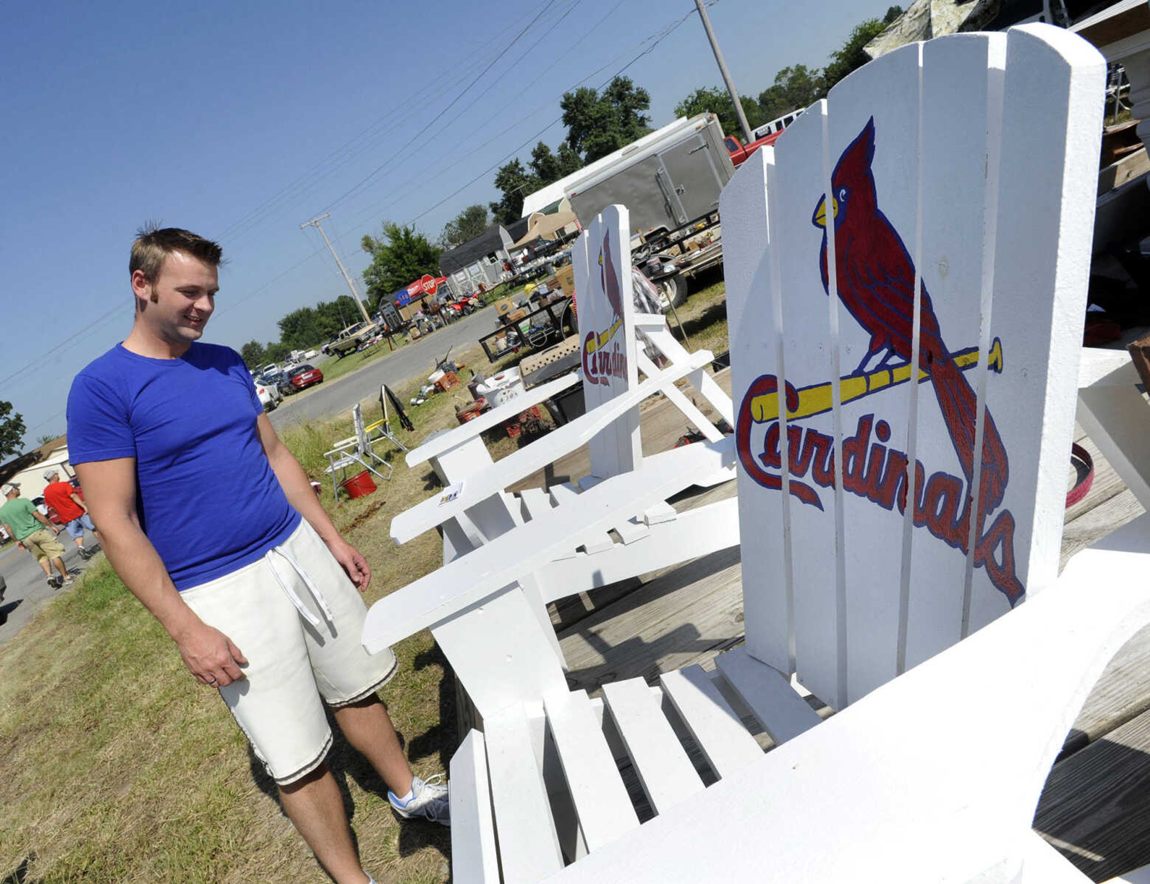 Dusty Statler of Oak Ridge, Mo. considers the custom Adirondack chairs on display by Jason and Heather Lee with CreativeLee Projects of Charleston, Mo. during the Highway 61 Yard Sale Saturday, Aug. 31, 2013 in Fruitland.