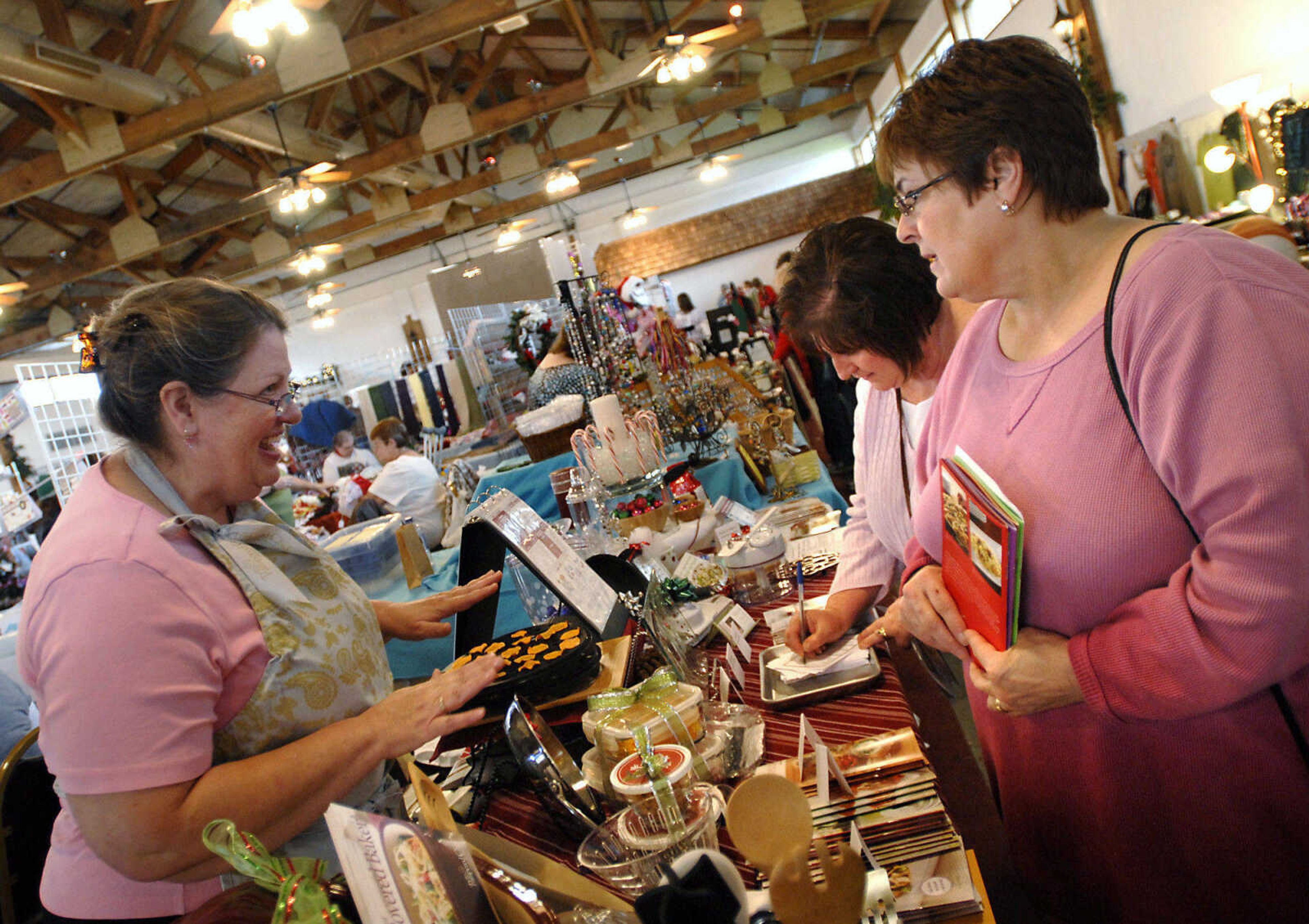 KRISTIN EBERTS ~ keberts@semissourian.com

Sharon Morris, right, and Penny Eisenhauer look at The Pampered Chef products from Pam Markin, left, from during the Christmas Extravaganza Crafts, Gifts and Collectibles Show at the Bavarian Halle in Jackson on Saturday, Nov. 19, 2011.