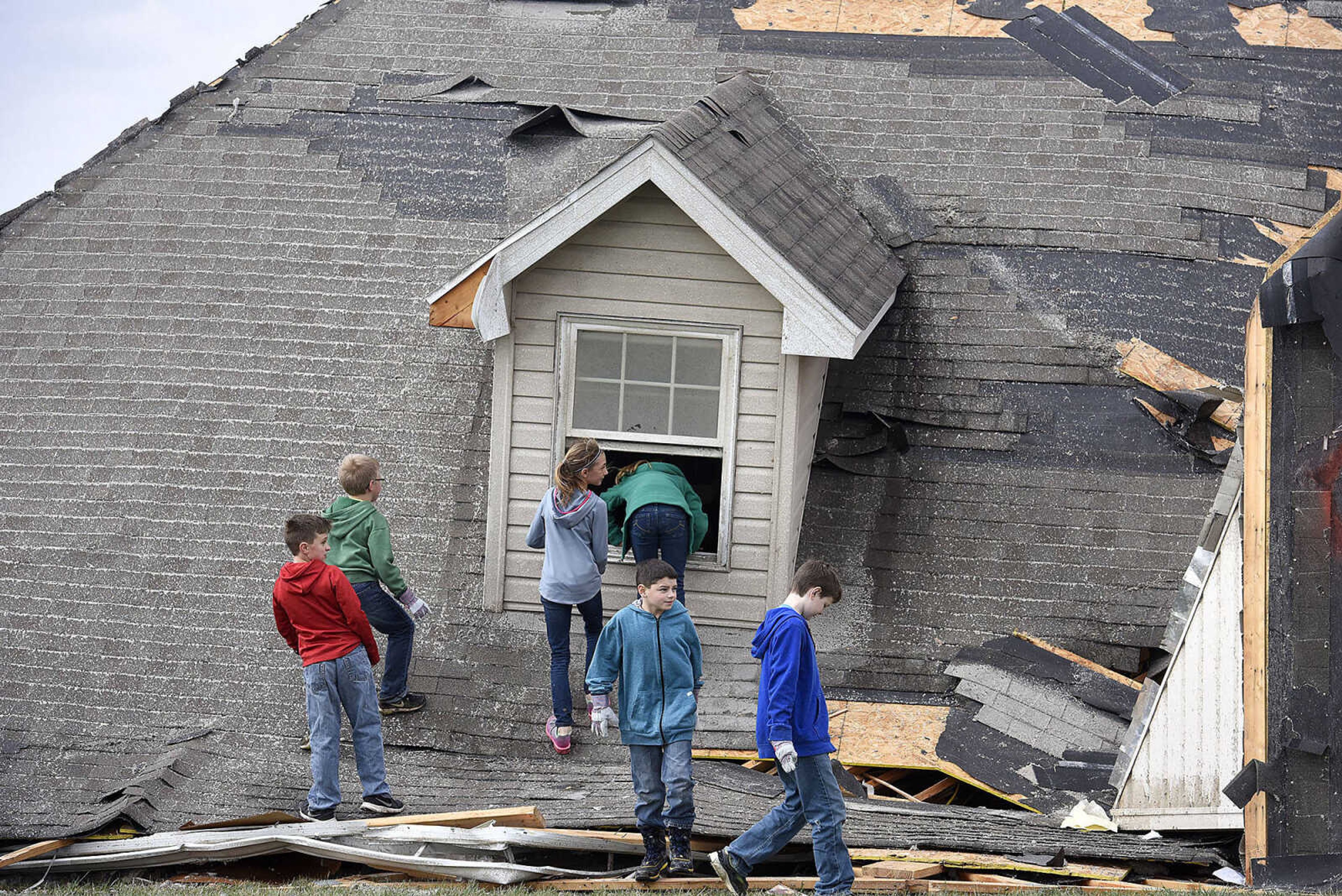 People help cleanup the damage left behind from a tornado along Perry County Road 806 near Kyle Lane on Wednesday, March 1, 2017, in Perryville. The tornado struck Tuesday night, crossing Interstate 55.