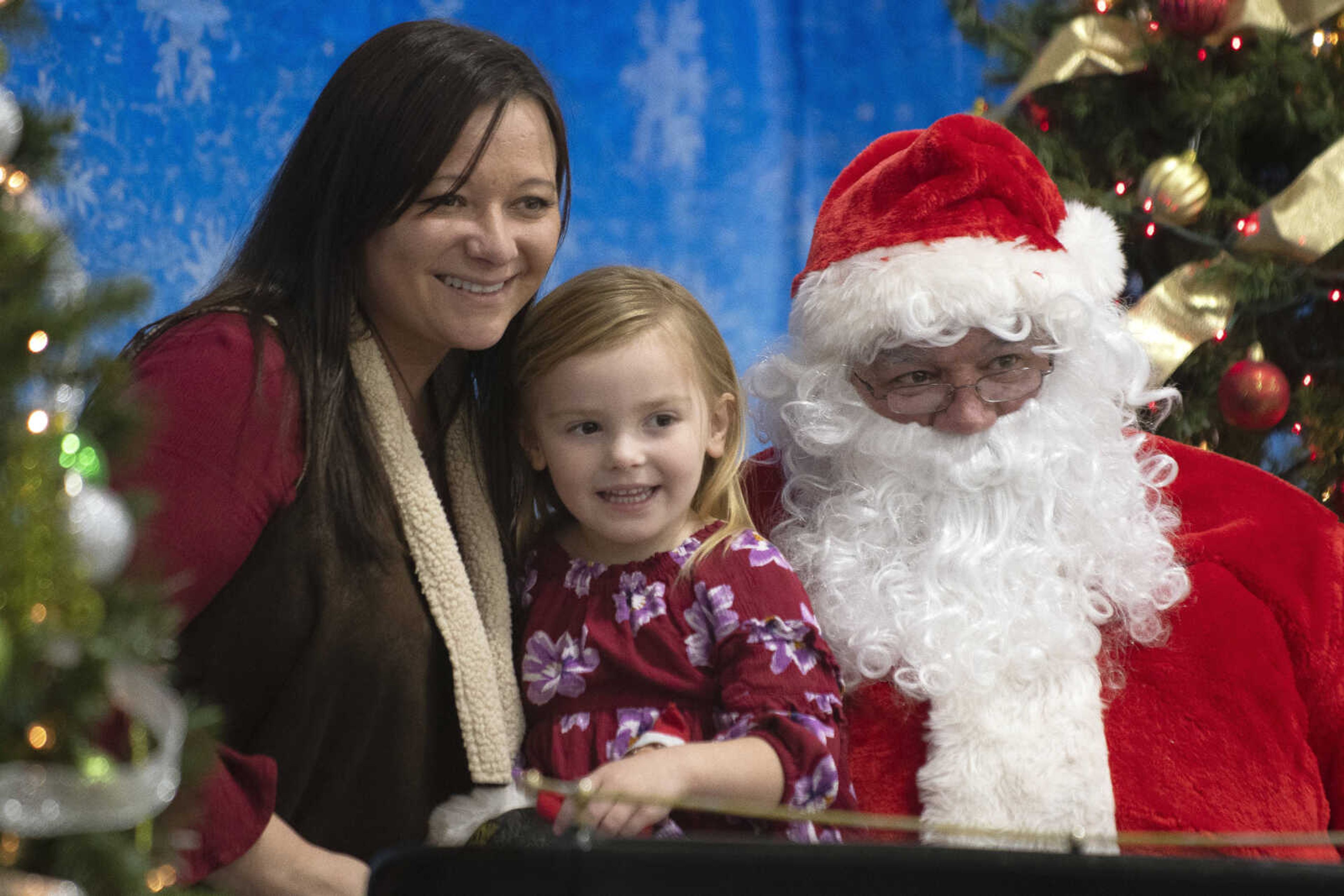 Alabama Gianesin, 4, of Cape Girardeau has her picture taken with her mother Erica Gianesin and Santa Claus, portrayed by City of Cape Girardeau Parks &amp; Recreation parks division manager Brock Davis, during the Cape Parks &amp; Recreation Foundation's Breakfast with Santa event Saturday, Dec. 14, 2019, at the Osage Centre in Cape Girardeau.