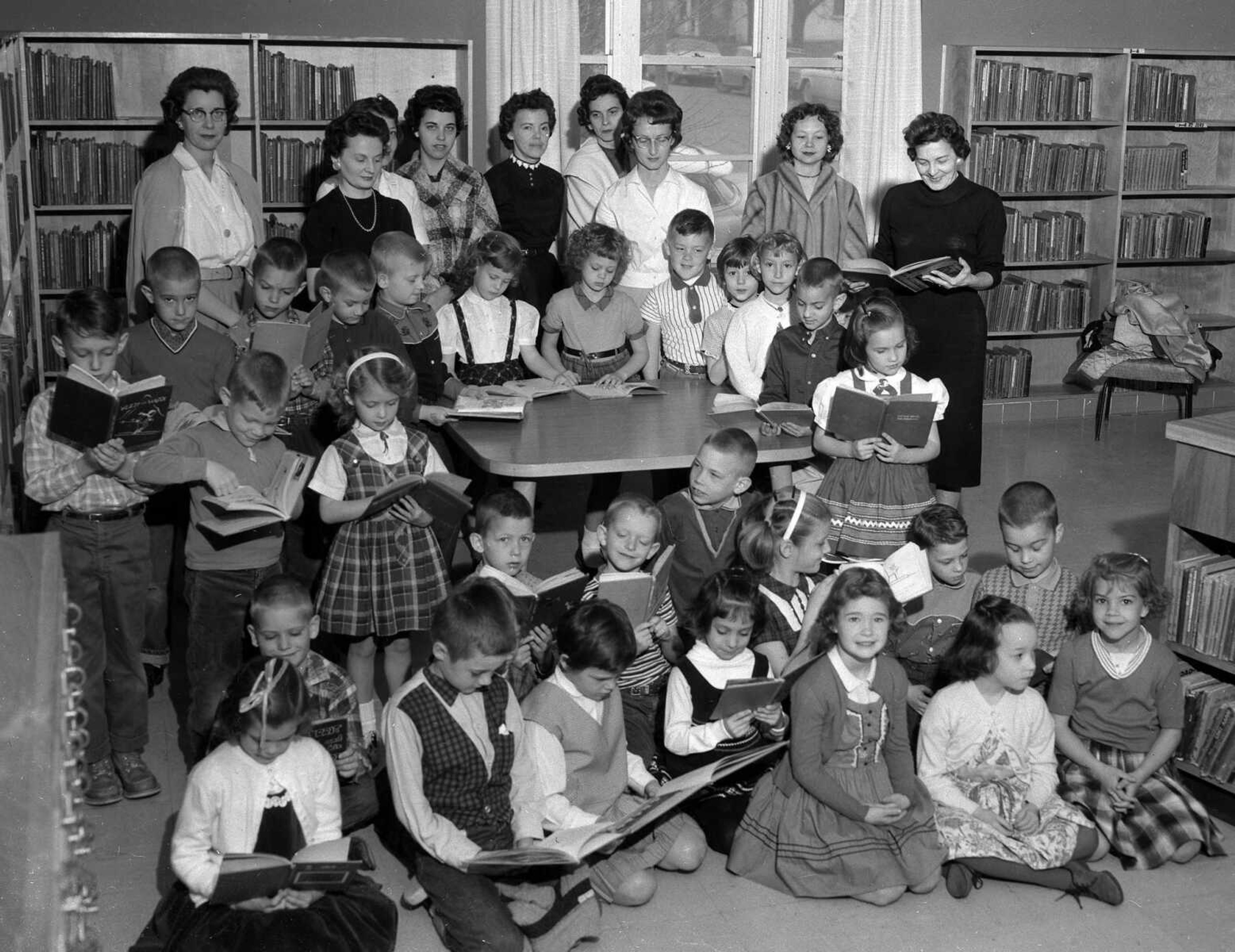 March 7, 1961 Southeast Missourian.
A tour of the Public Library Friday spurred the interest in independent reading of first graders taught by Mrs. Viola Young at Franklin School and who now are reading the book, “Our New Friends” and looking forward to meeting many new storybook friends in other new books. 

Librarian, Miss Mary Kempe, welcomed the children who were permitted to browse through the books and choose their own for reading, and Mrs. Young read them the story, “When the Root Children Wake Up.” For her kindness to them, the pupils presented a gift to Miss Kempe.

On the tour were: Barbara Baltz, Mike Borth, Billy Bonge, David Bertrand, Stephen Boren, Mike Brame, Joe Boyd, Jill Brunton, Donna Criddle, Kathy Crites, Stephen Eakins, John Eldridge, Cindy Givens, Cindy Heller, Debbie Kirby, Brad Kirtley, Dobby Lacy, Mark McLaird, Jill Miller, Robert Nicholas, David Payne, Patti Palsgrove, Randy Proffer, Joe Popp, Gary Powell, Bonita Seabaugh, Debby Storz, Janet Weber and Cindy Wittich. (G.D. Fronabarger/Southeast Missourian archive)