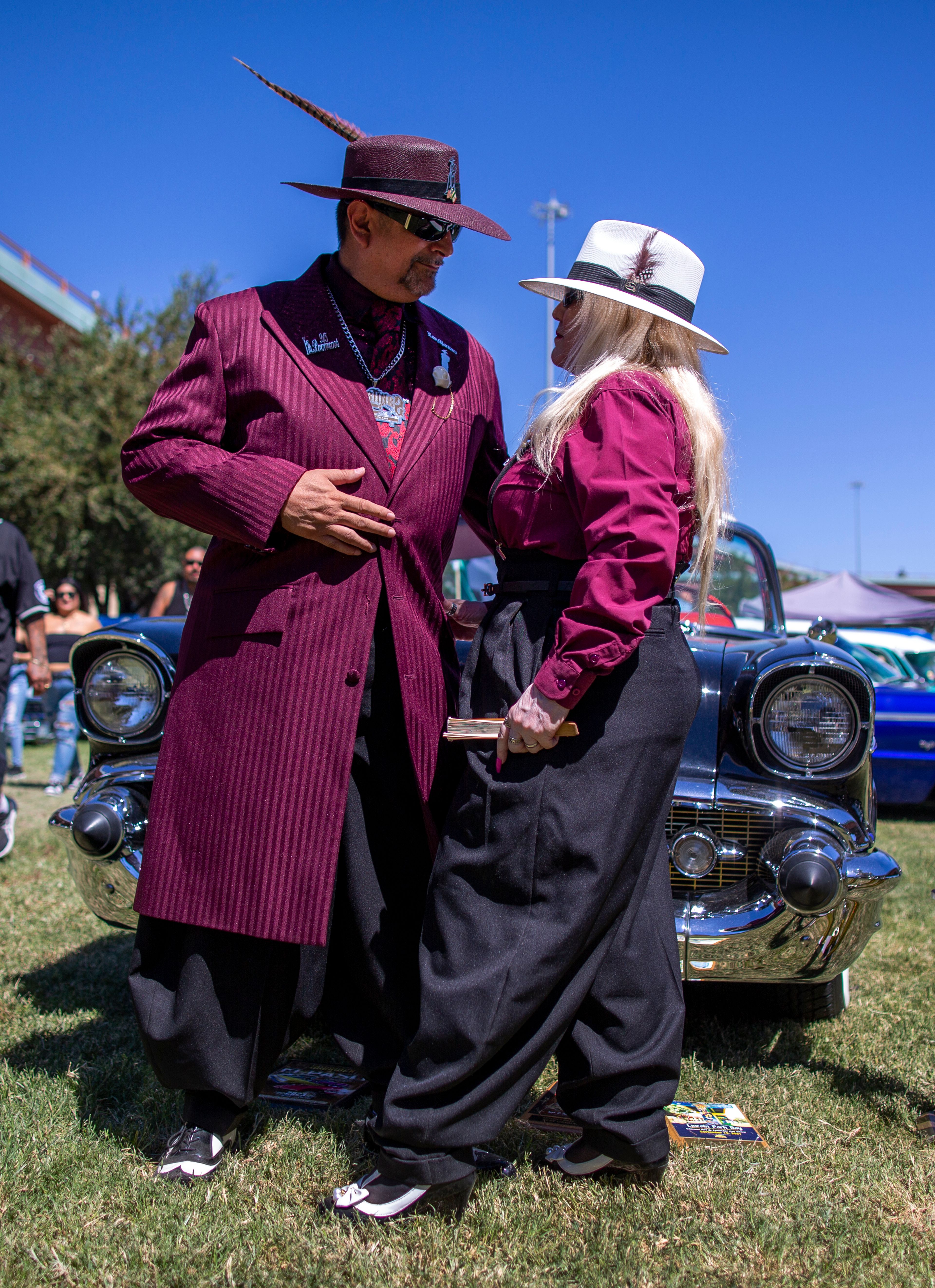 Wearing Zoot suits of the Mexican American subculture known as Pachucos, Cisco and Güera Martinez pose for a photo while attending a lowrider exhibition during the 20th anniversary of Lincoln Park in El Paso, Texas, Sunday, Sept. 22, 2024. (AP Photo/Andrés Leighton)