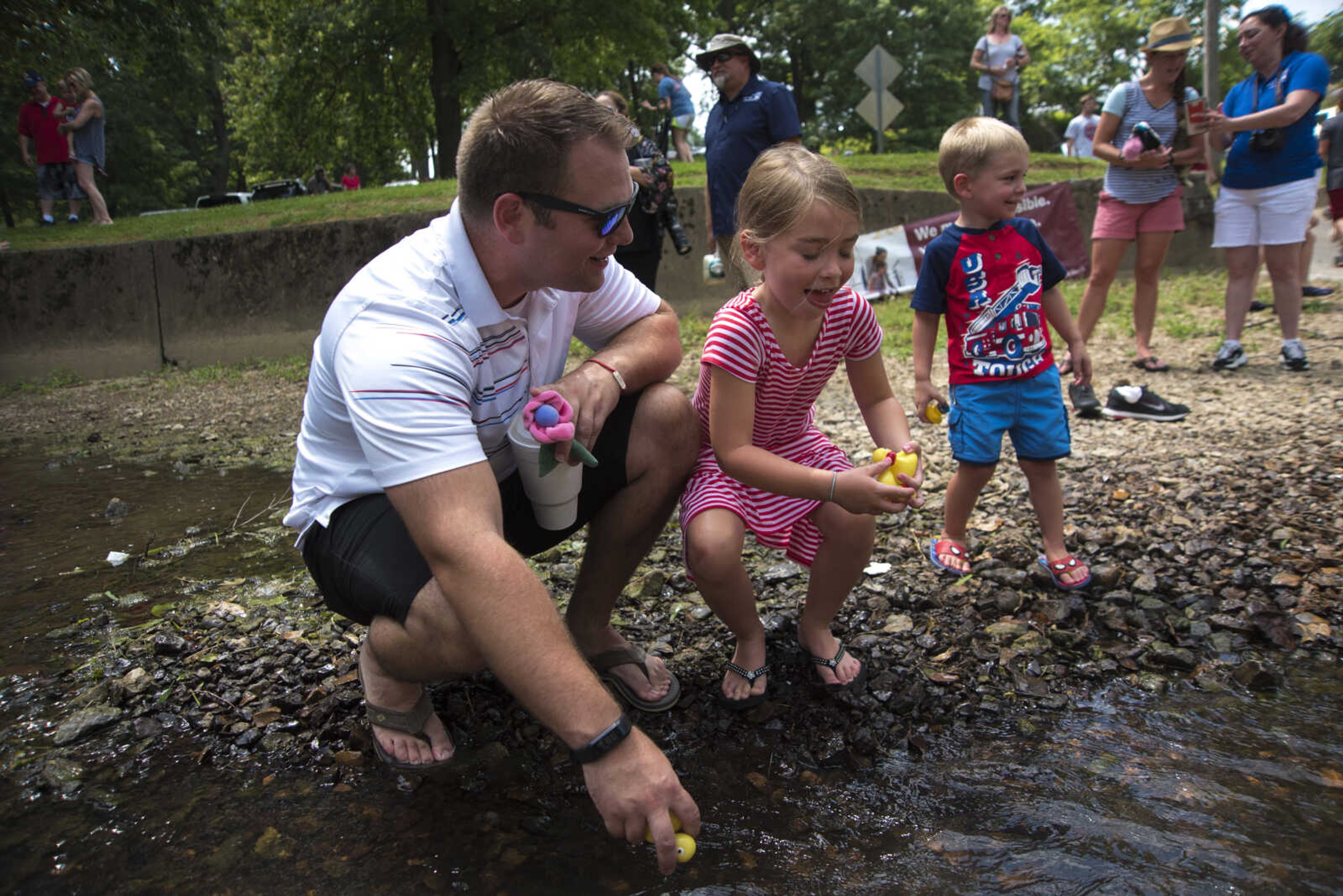 Ronnie Maxwell and his daughter Anniston Maxwell, 5, pick up rubber ducks after the duck race for the Jackson Parks and Recreation's July 4th celebration Tuesday, July 4, 2017 in Jackson City Park.