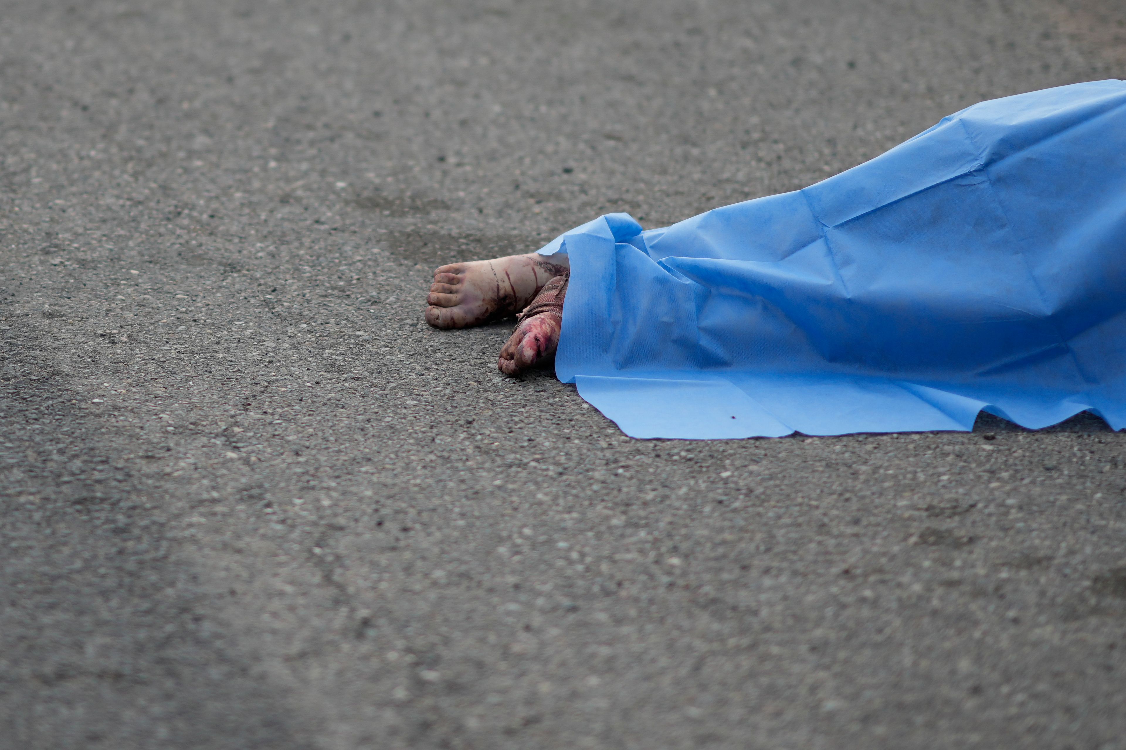 A blue sheet covers a body found lying on the side of a road in Culiacan, Sinaloa state, Mexico, Saturday, Sept. 21, 2024. (AP Photo/Eduardo Verdugo)