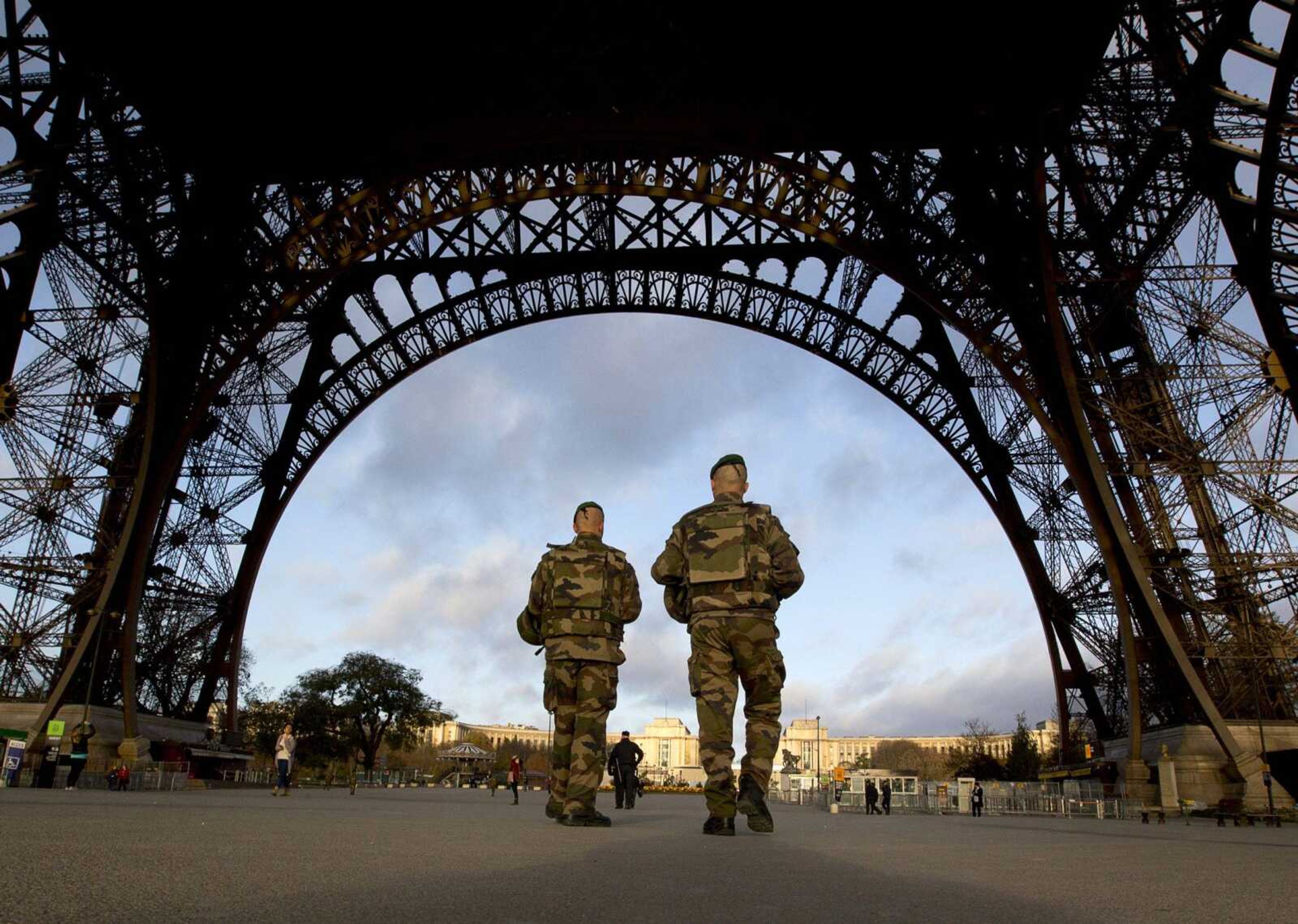 French soldiers patrol at the Eiffel Tower, which remained closed Sunday on the first of three days of national mourning in Paris. Thousands of French troops deployed around Paris on Sunday, and tourist sites stood shuttered in one of the most visited cities on Earth while investigators questioned the relatives of a suspected suicide bomber involved in the country's deadliest violence since World War II. (Peter Dejong ~ Associated Press)