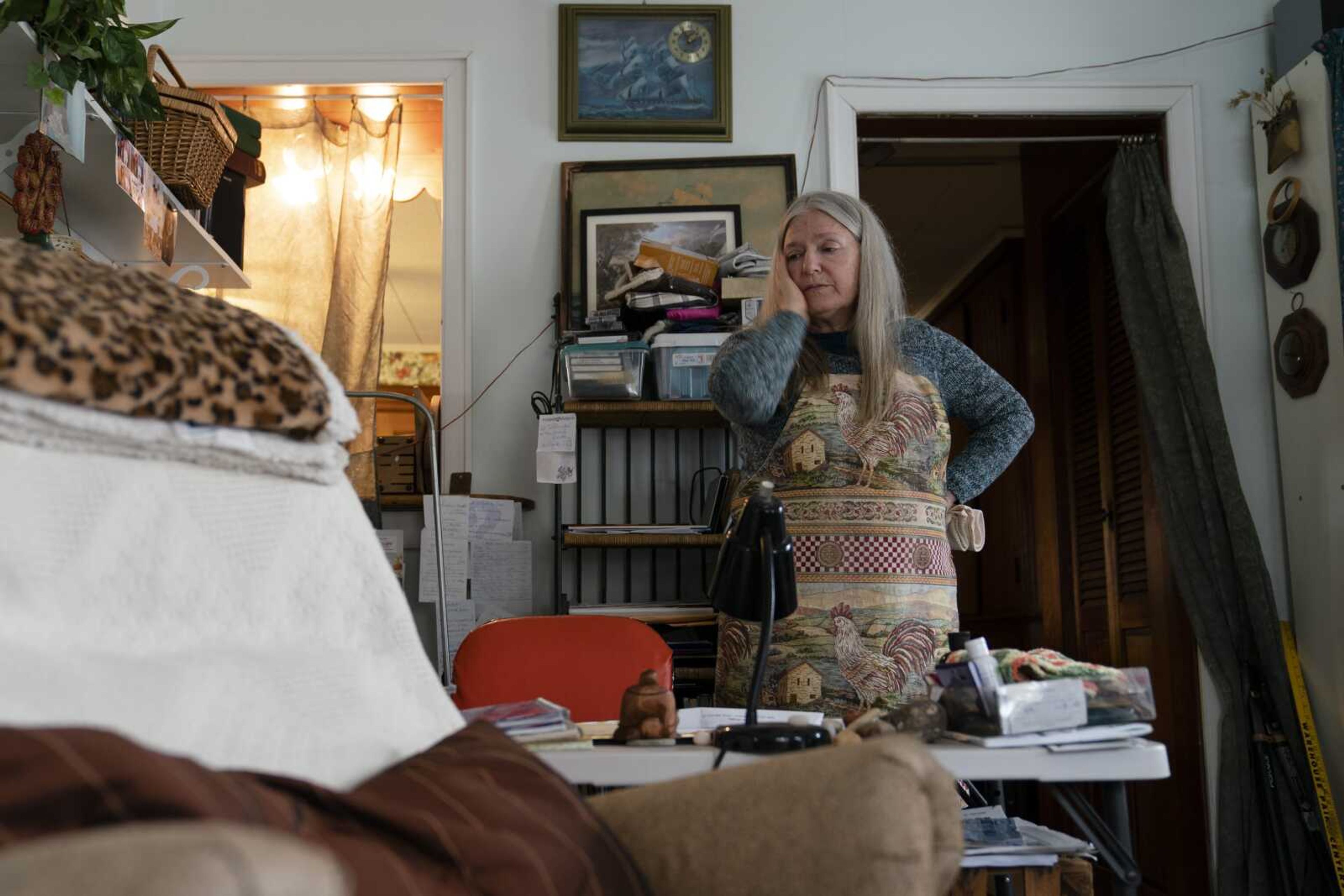 Nancy Rose, who contracted COVID-19 in 2021 and continues to exhibit long-haul symptoms including brain fog and memory difficulties, pauses while organizing her desk space Jan. 25 in Port Jefferson, New York. Rose, 67, said many of her symptoms waned after she got vaccinated, though she still has bouts of fatigue and memory loss. A report from the Centers for Disease Control and Prevention released Wednesday found that up to a year after an initial coronavirus infection, 1 in 4 adults aged 65 and older had at least one potential long COVID health problem, compared with 1 in 5 younger adults.