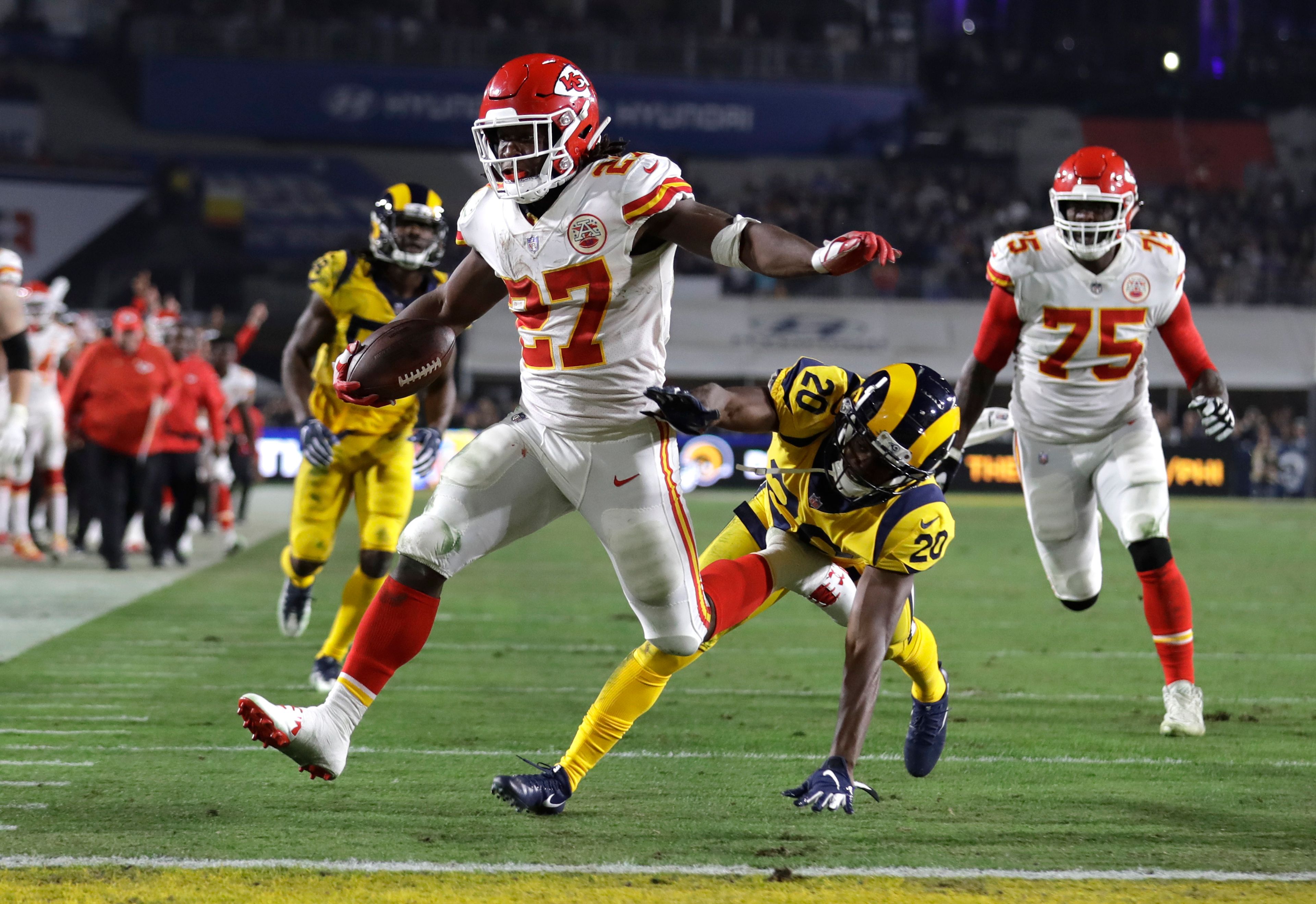 FILE - Kansas City Chiefs running back Kareem Hunt (27) scores a touchdown ahead of Los Angeles Rams free safety Lamarcus Joyner (20) as Chiefs offensive guard Cameron Erving (75) looks on during the first half of an NFL football game, Monday, Nov. 19, 2018, in Los Angeles. (AP Photo/Marcio Jose Sanchez, File)