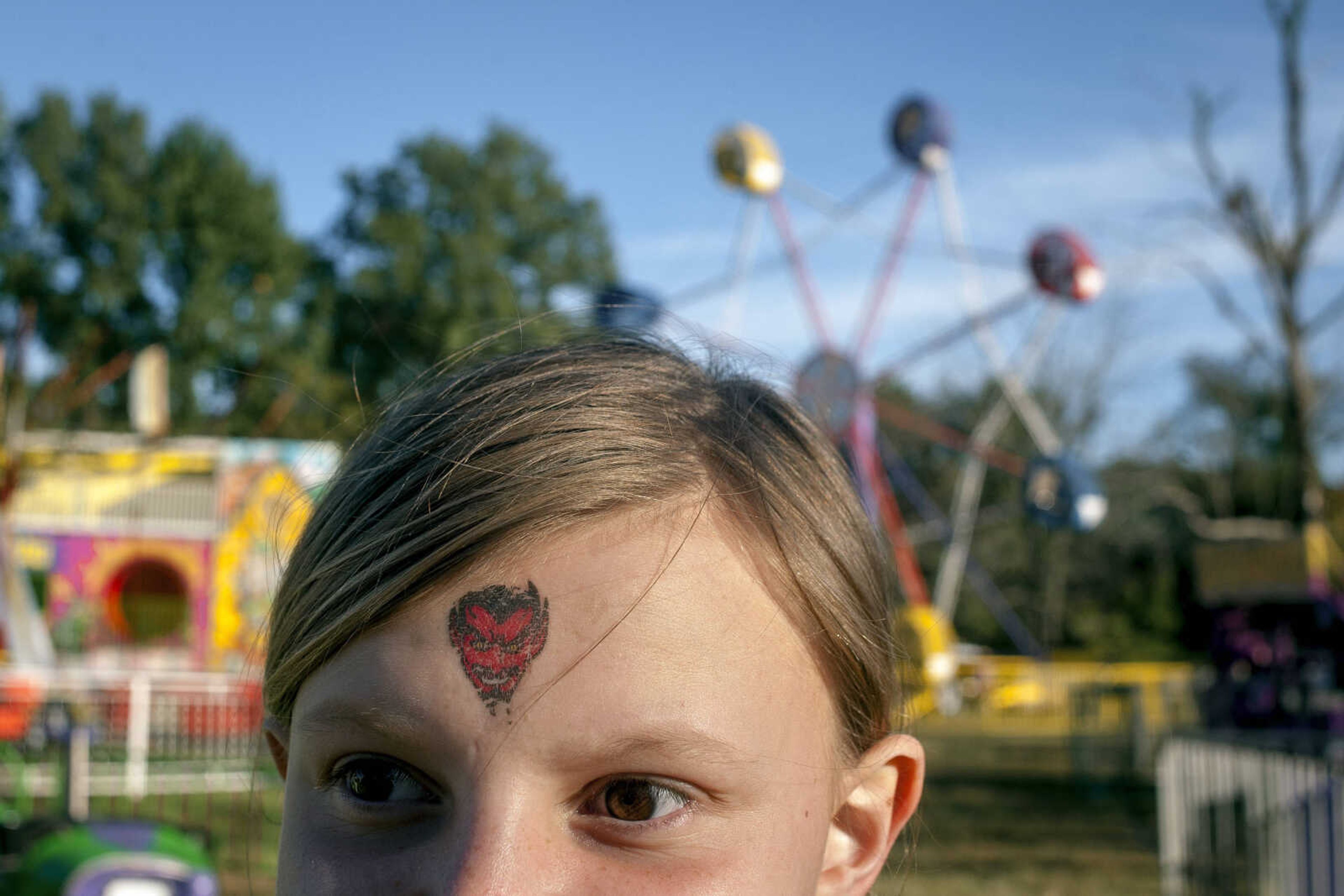 A temporary tattoo depicting the Chaffee Red Devil (the local high school mascot) is seen on the forehead of Jazmine Sadler during Chaffee German Days on Saturday, Oct. 12, 2019, at Frisco Park in Chaffee.