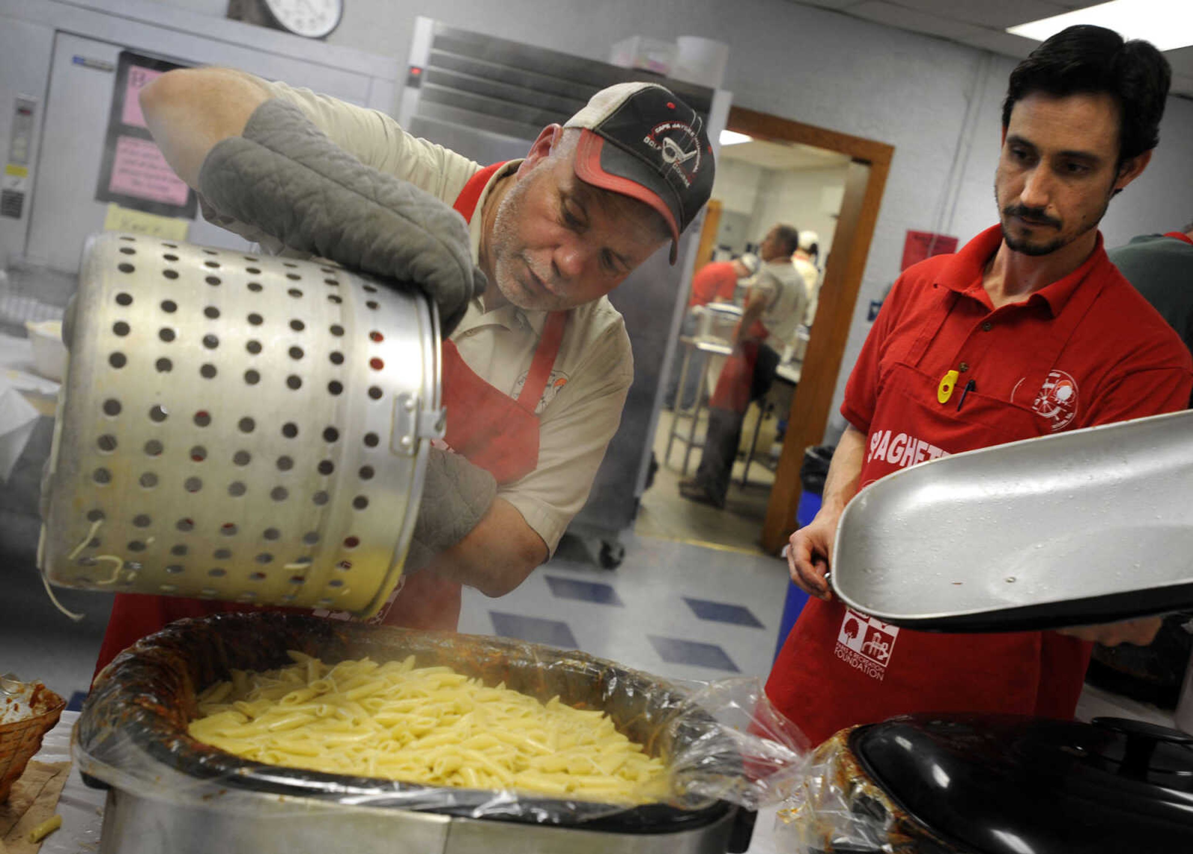 Randy Lueder, left, brings hot mostaccioli for Patrick Watson at the Parks & Recreation Foundation Spaghetti Day Wednesday, Nov. 13, 2013 at the Arena Building.